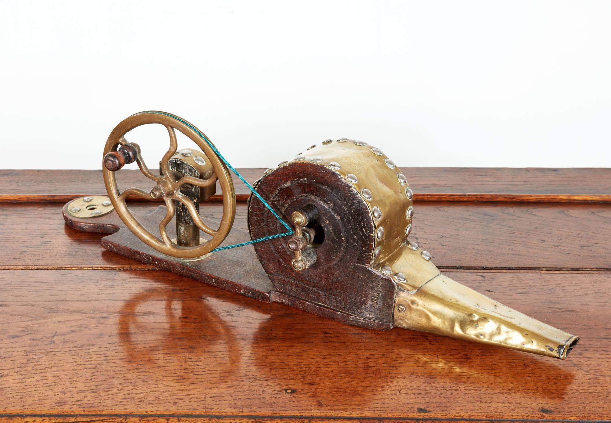English early 19th century mechanical bellows having wavy spoke solid brass wheel and studded brass bellow chamber with patinated mahogany body.   Use as  bellows or as a decorative shelf or desk object.