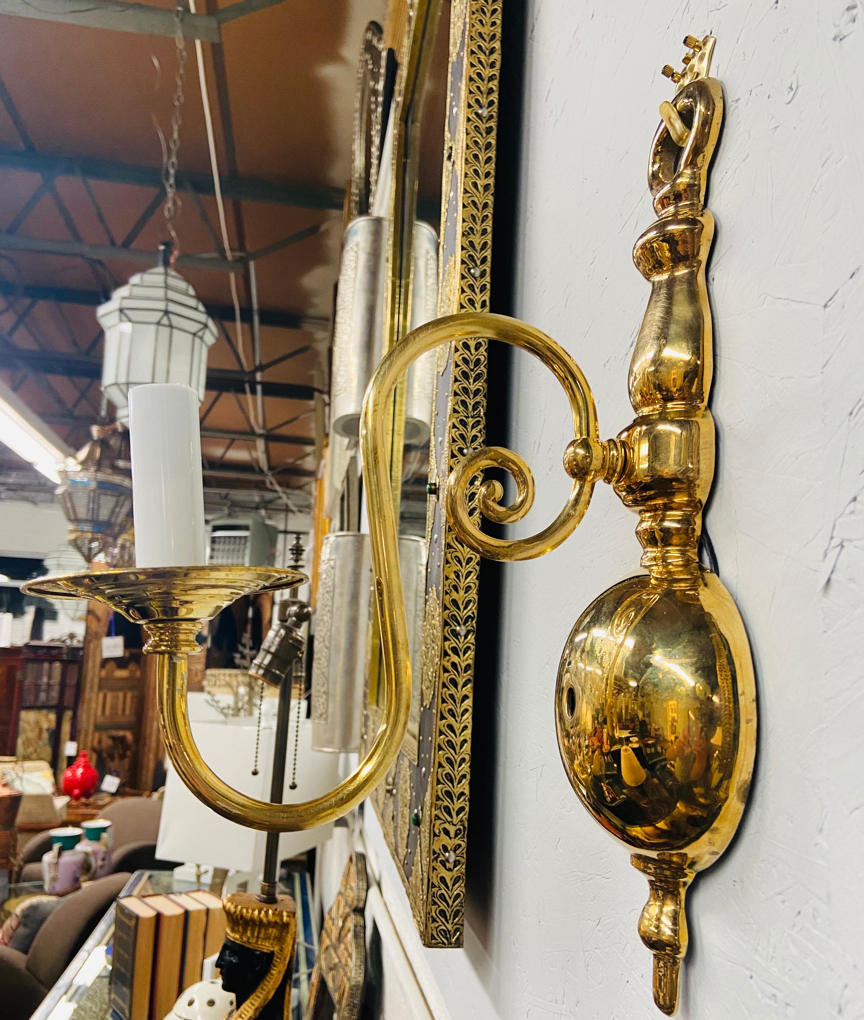 A pair of Georgian brass wall sconces. Each sconce holds one candelabra and with a fine arm ending in a scroll design. Classy and refined, this pair will add of sophistication to your wall design.

Dimensions: 13