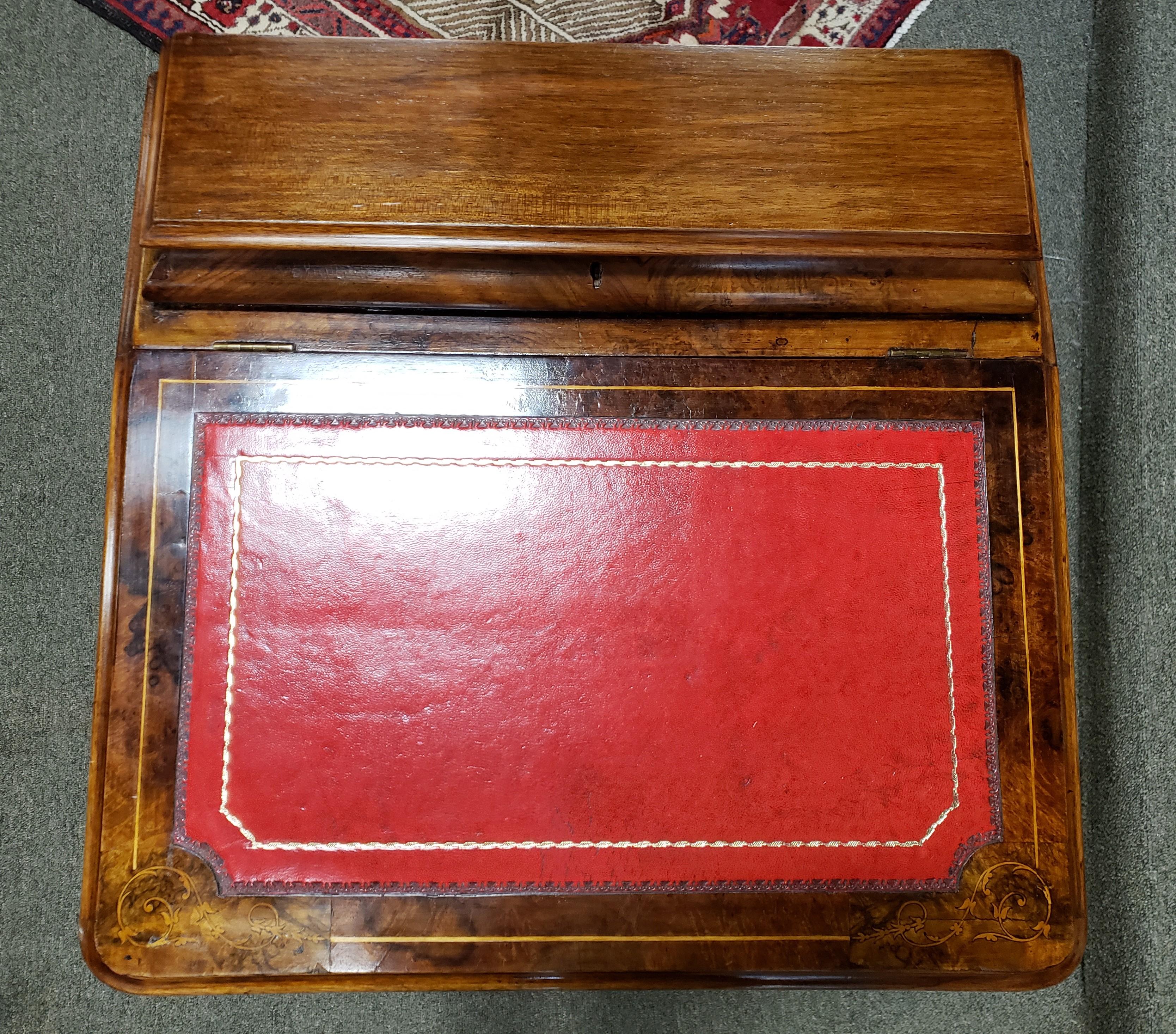 Georgian mahogany and burl walnut davenport. The top has a leather writing surface with foliate inlay surrounding it. The front is bookmatched walnut showing extensive figural detail. The sides consist of 4 drawers on the right side and 4 faux