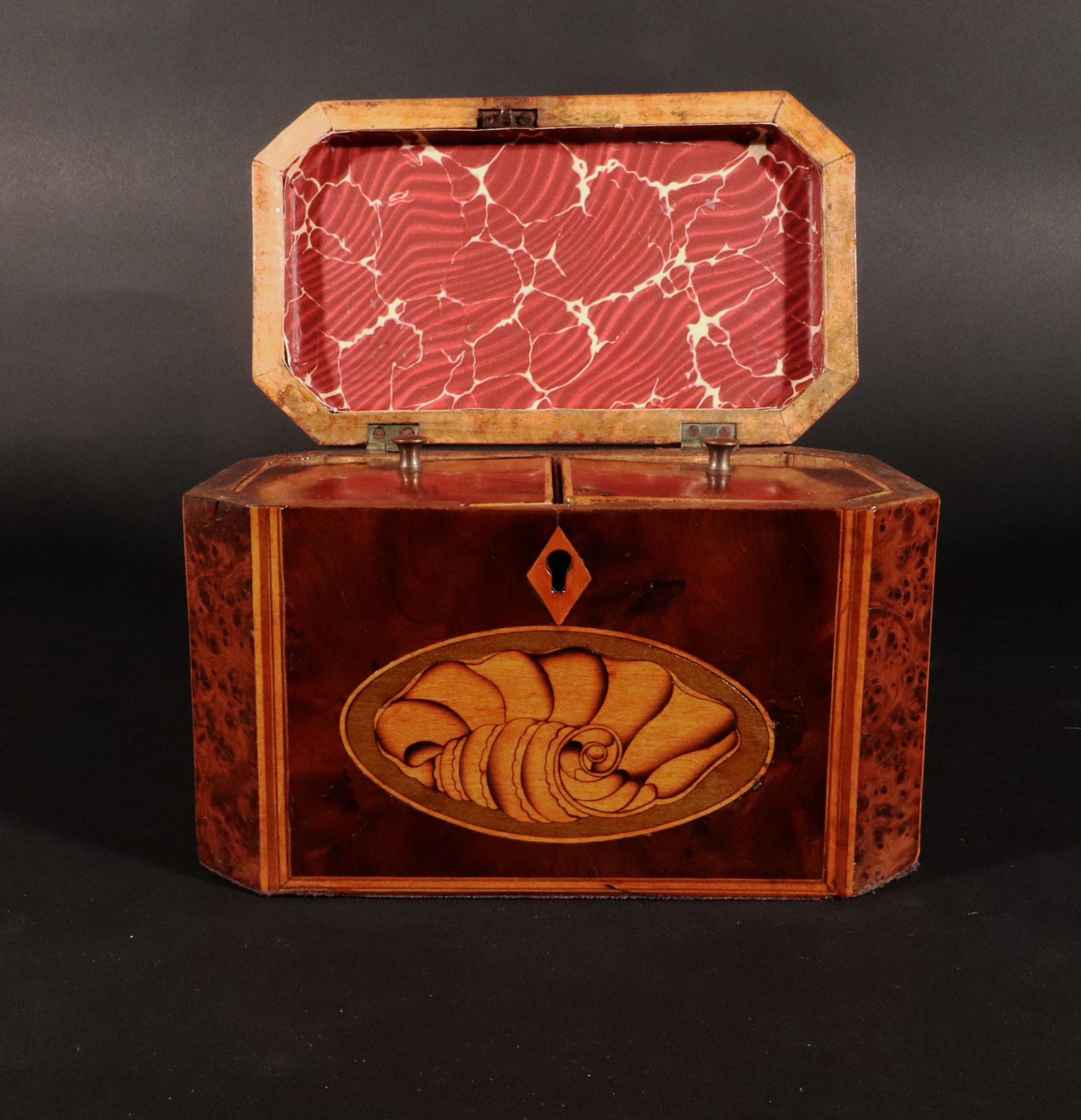 George III Burl Yew and Satinwood Octagonal Tea Caddy with Conch Shell Panels,
Circa, 1790, 

The burl yew double tea caddy is of an octagonal form with canted corners. The interior with two section for different types of tea, the sections with
