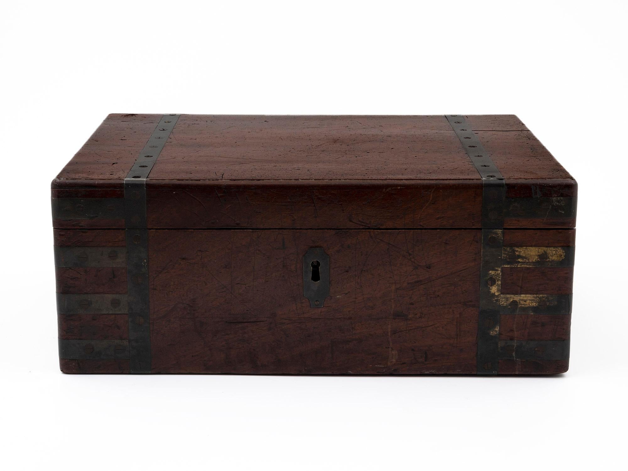 Antique military captain's writing box with brass strapping, secret compartment and special large steel key to secure the box for stability on the shores or military manoeuvres!

The magnificent box is constructed of dense solid Mahogany with