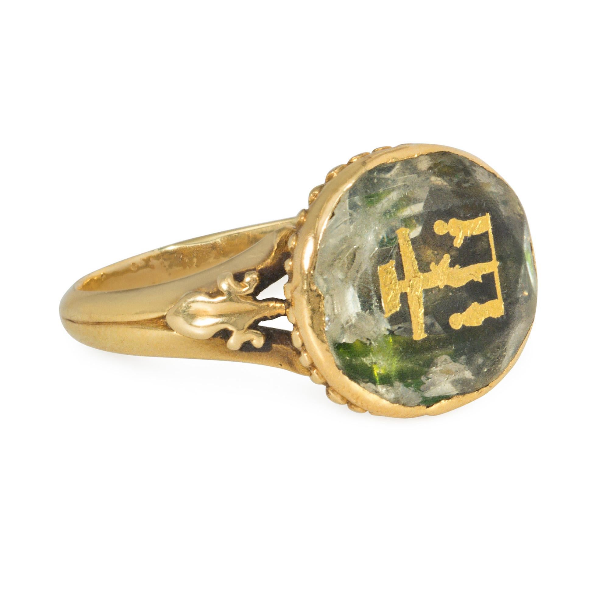 An antique Georgian period gold and oval foiled-back citrine ring featuring the martyrdom of Christ with two mourners, with fluted undergallery and split shoulders accented with leaf motifs, in 18k.

Face-up: approximately 12mm x 13mm