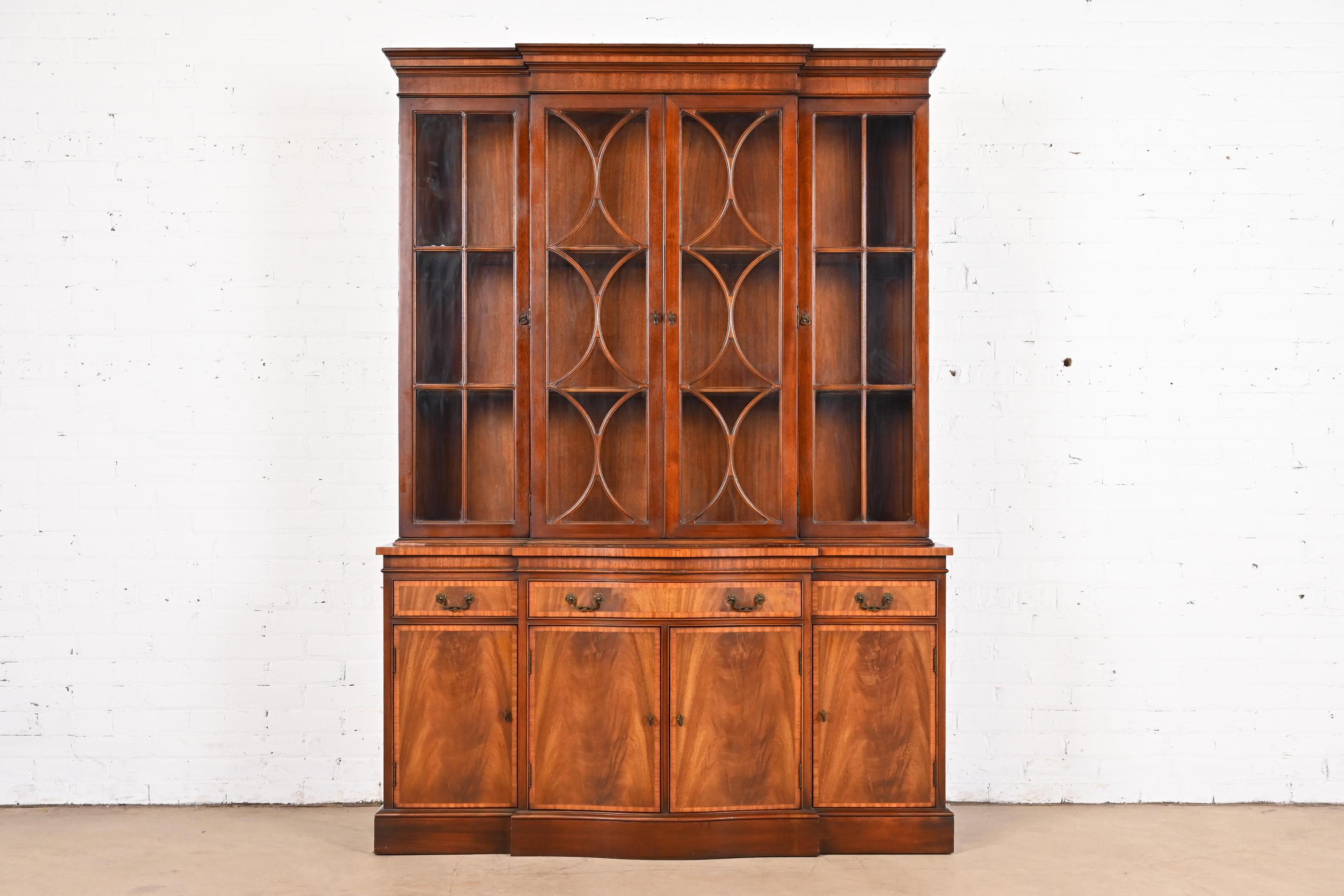 A gorgeous Georgian or Chippendale style breakfront bookcase or dining cabinet

By Fancher Furniture Co.

USA, Circa 1940s

Beautiful book-matched flame mahogany, with mullioned glass front doors, and original brass hardware.

Measures: 55.5