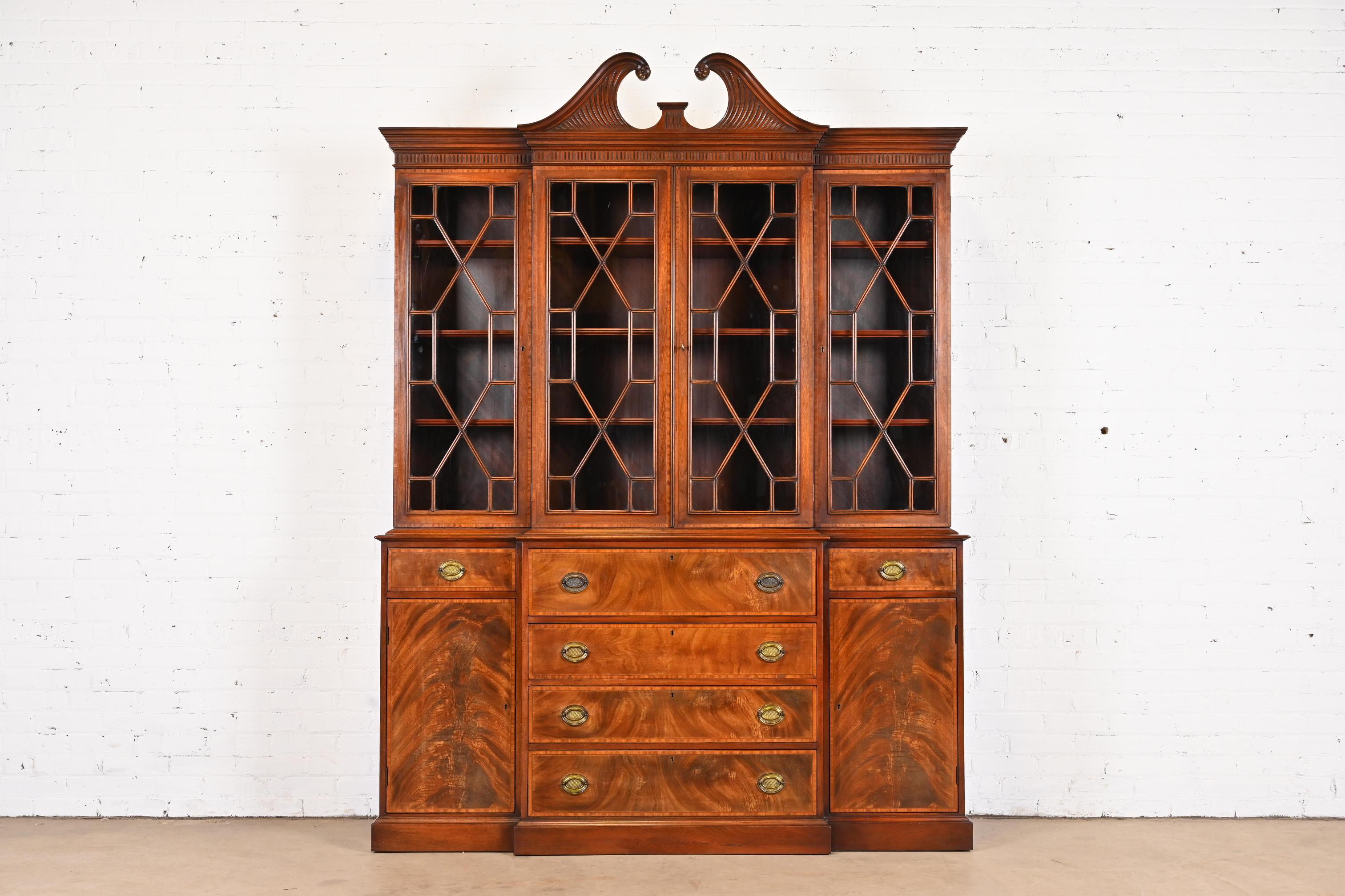 A gorgeous Georgian or Chippendale style breakfront bookcase or china cabinet with secretary desk

By Beacon Hill

USA, Mid-20th Century

Flame mahogany, with mullioned glass front doors, original brass hardware, and embossed green leather