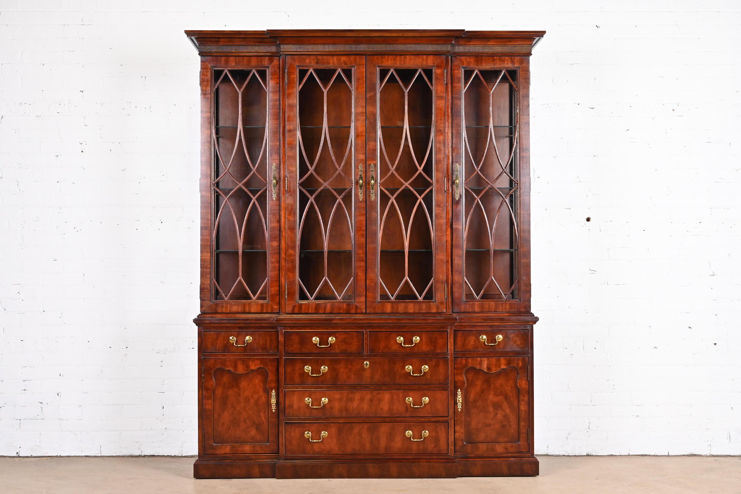 A gorgeous Georgian or Chippendale style lighted breakfront bookcase or dining cabinet

By Thomasville

USA, circa 1980s.

Flame mahogany, with mullioned glass front doors and original brass hardware. Lights have been tested and are
