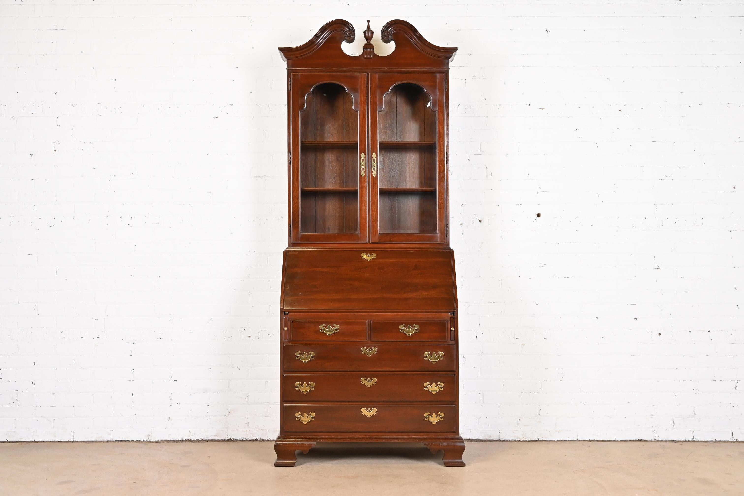 A beautiful Georgian or Chippendale style bureau with drop front secretary desk and bookcase hutch top

USA, Late 20th Century

Gorgeous carved solid cherry wood, with original brass hardware and glass front doors.

Measures: 36.25