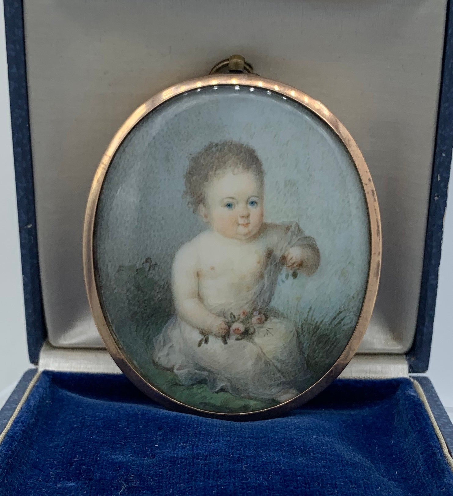 This is a very early and rare Museum Quality Georgian Locket Pendant Necklace with an extraordinary hand painted portrait miniature of a child in a field of grass with a bouquet of roses and in a 10-12 Karat Gold Locket Frame.  The portrait