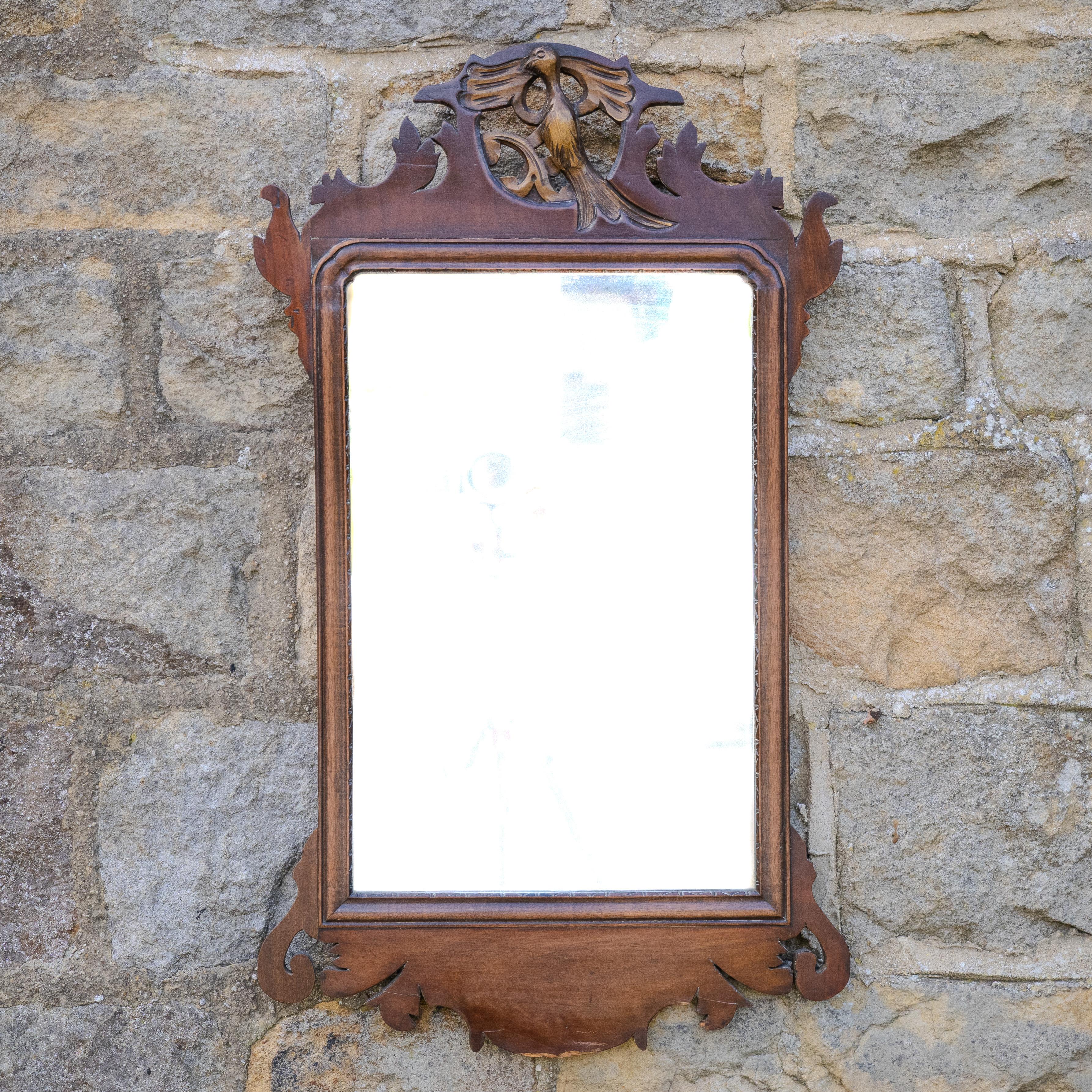 Piccolo specchio da parete in noce e traforo dorato, risalente all'inizio del XIX secolo, con design Chippendale.  Specchio da parete con cornice a traforo impiallacciata in noce, lastra specchiata oblunga con un'apertura a forma di croce.  bordo