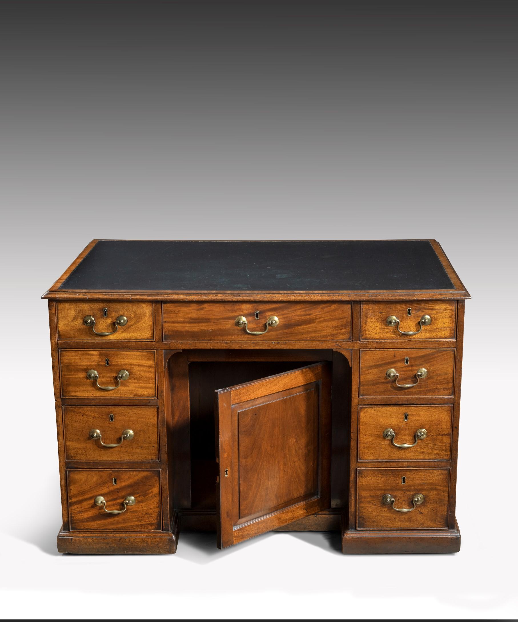 A Georgian Chippendale period mahogany pedestal desk, the desk's leathered top crossbanded in mahogany above three frieze drawers to the front with a central recessed panelled door flanked by banks of three graduated drawers, to the rear of the desk