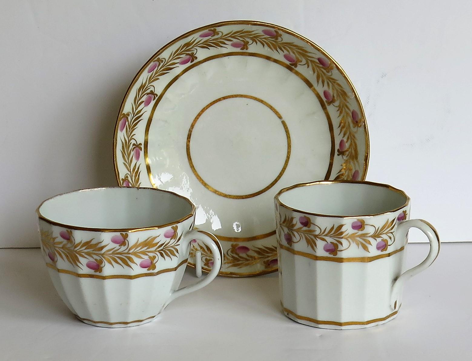 Il s'agit d'un trio de porcelaine ancienne comprenant une boîte à café à cannelures verticales, une tasse à thé et une soucoupe, le tout dans un motif peint à la main et doré, que nous attribuons à CIRCA, John Rose & Co, Shropshire, Angleterre,