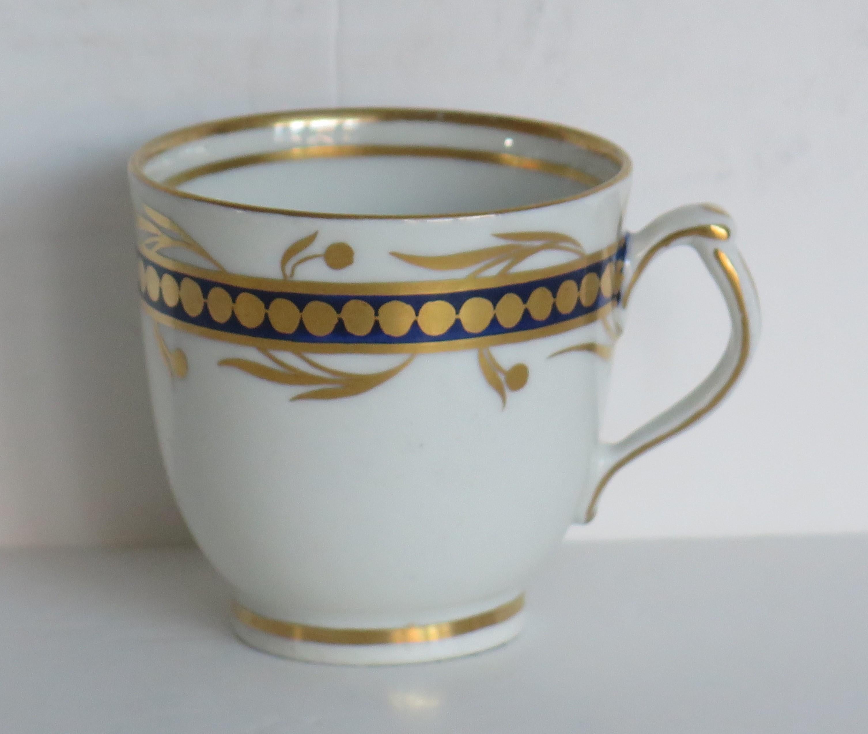 Il s'agit d'une tasse à café en porcelaine, attribuée à un fabricant anglais du Staffordshire, au début du XIXe siècle, période George 111, vers 1805-1810.

La pièce est bien empotée sur un pied bas avec une poignée en boucle unie, ayant un éperon