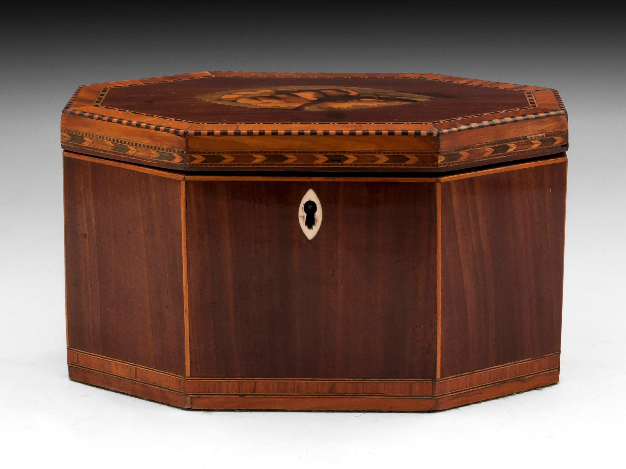 Antique Octagonal tea caddy with conch shell inlay to the top, with chequered edging with satinwood cross banding and oval shaped bone escutcheon. Surrounding the front edge is a herring bone inlay coloured boxwood inlays with the base having a