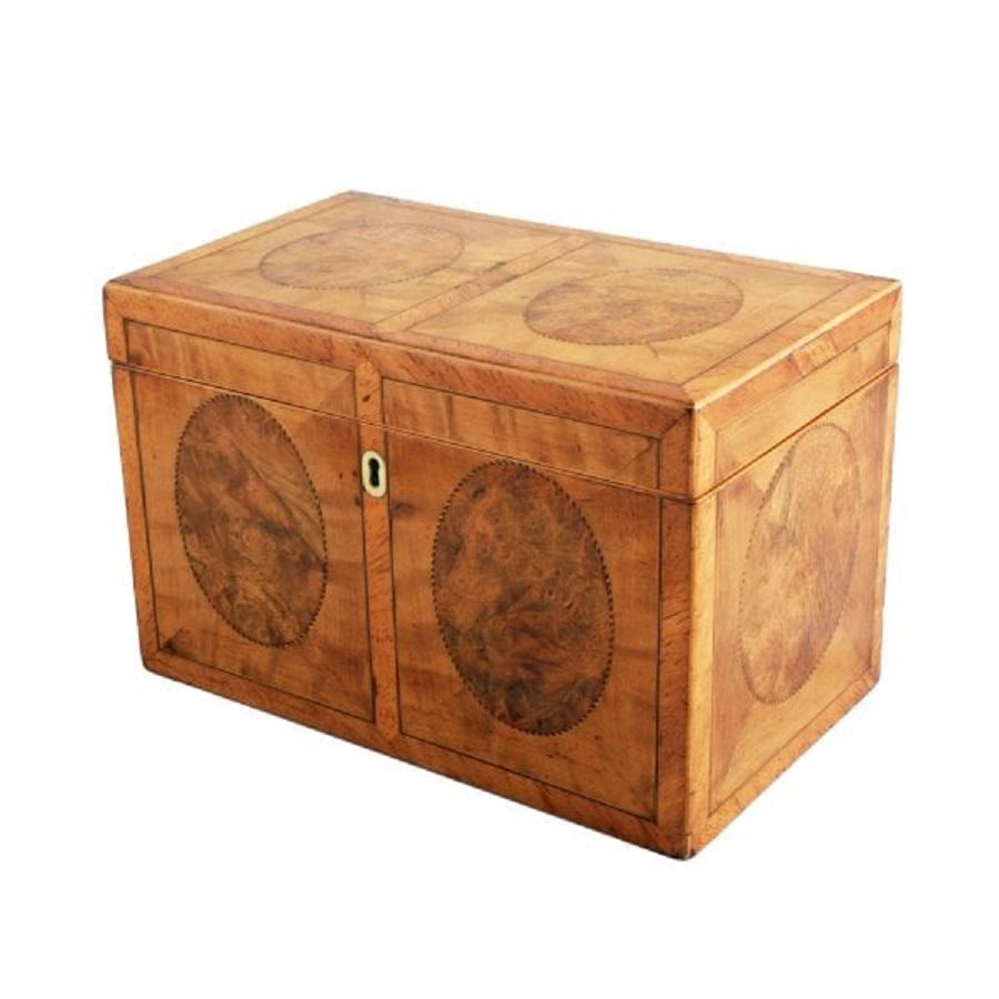 A late 18th to early 19th century Georgian satinwood tea caddy.

The caddy is satinwood veneered with oval panels of burr walnut edged with chequered inlay on all sides to match.

The caddy interior has been converted into a stationery box with