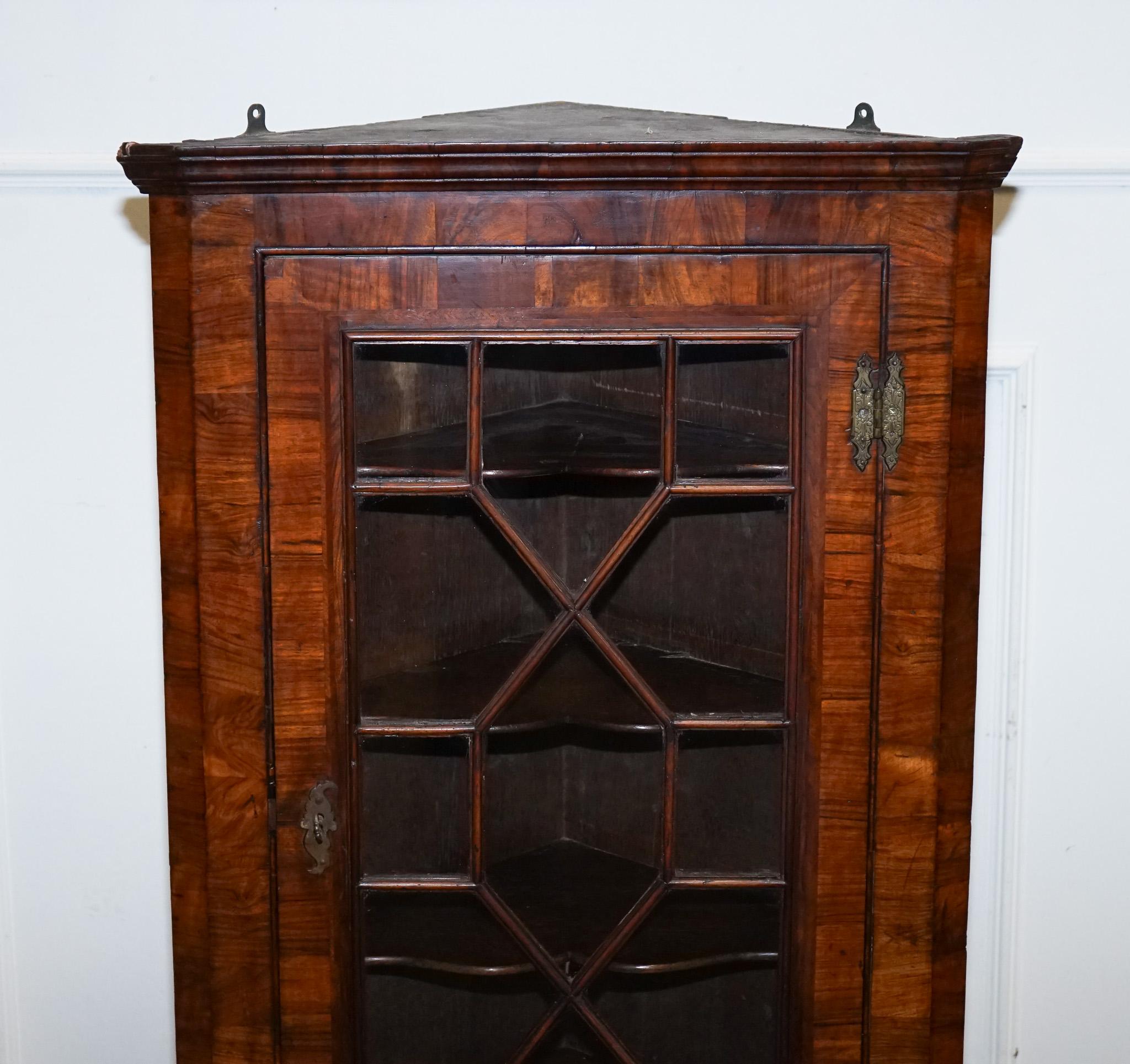 
Antiques of London



This elegant antique glazed corner cabinet is a fine example of Georgian-style craftsmanship, featuring a beautifully figured veneer, astral-glazed door, and finely moulded cornice. Designed to be wall-mounted, it offers both