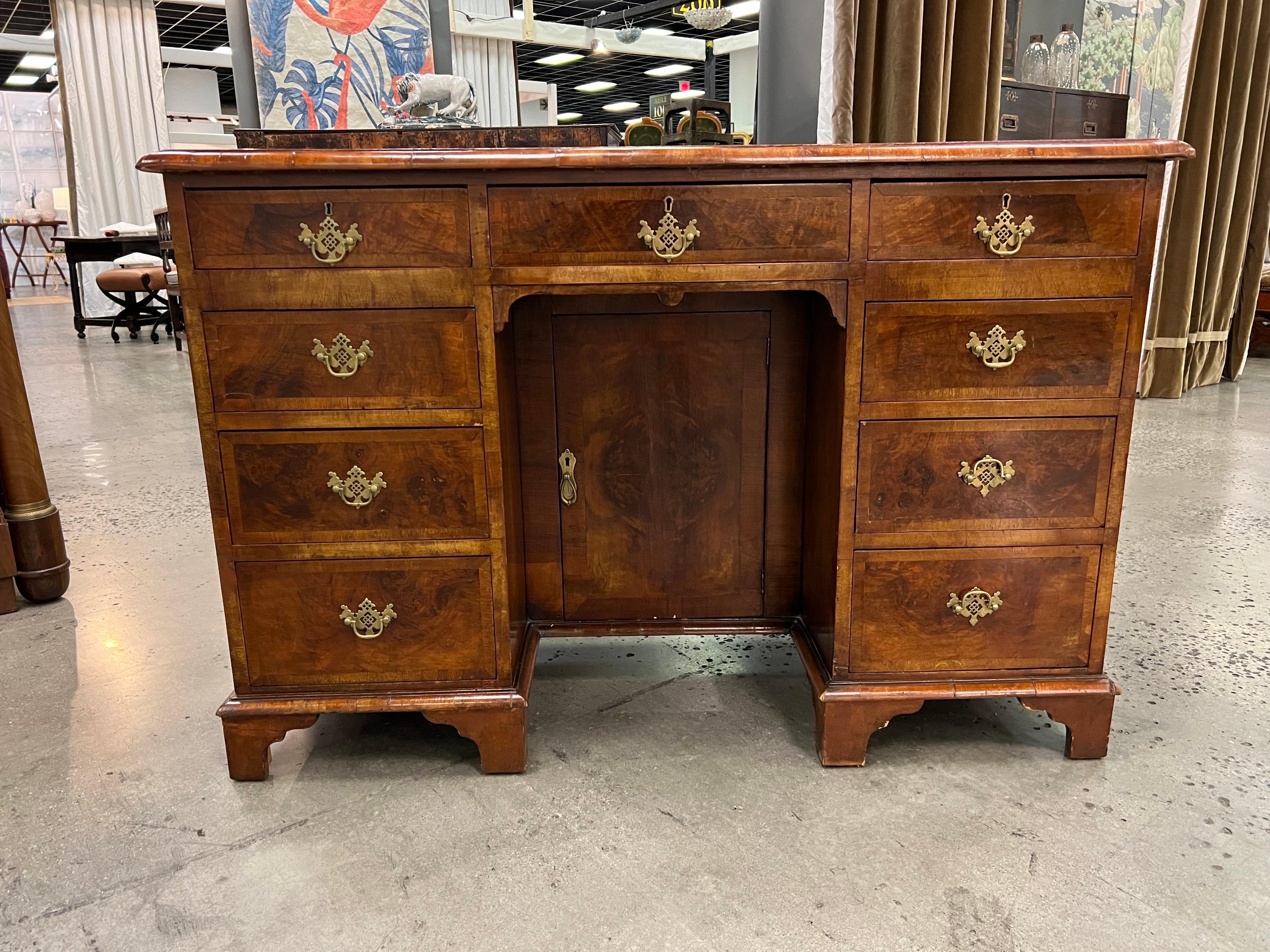 19th Century Georgian crossbanded walnut kneehole console. Rich color burl top with herringbone inlay and crossbanding over graduated drawers and kneehole cabinet resting on bracket feet.