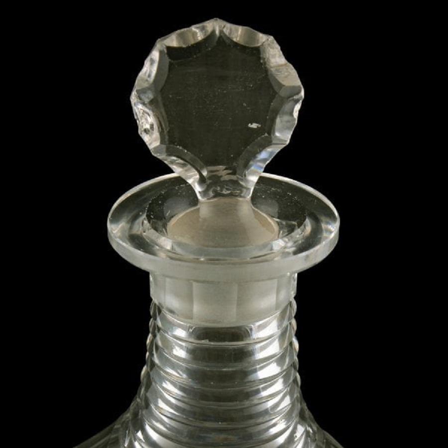 An early 19th century Georgian cut glass decanter and stopper.

The decanter has facet cut shoulders, the neck has parallel line stepped cutting and the lower edge is facet cut with a star cut and ground underneath.

The stopper is flat sided