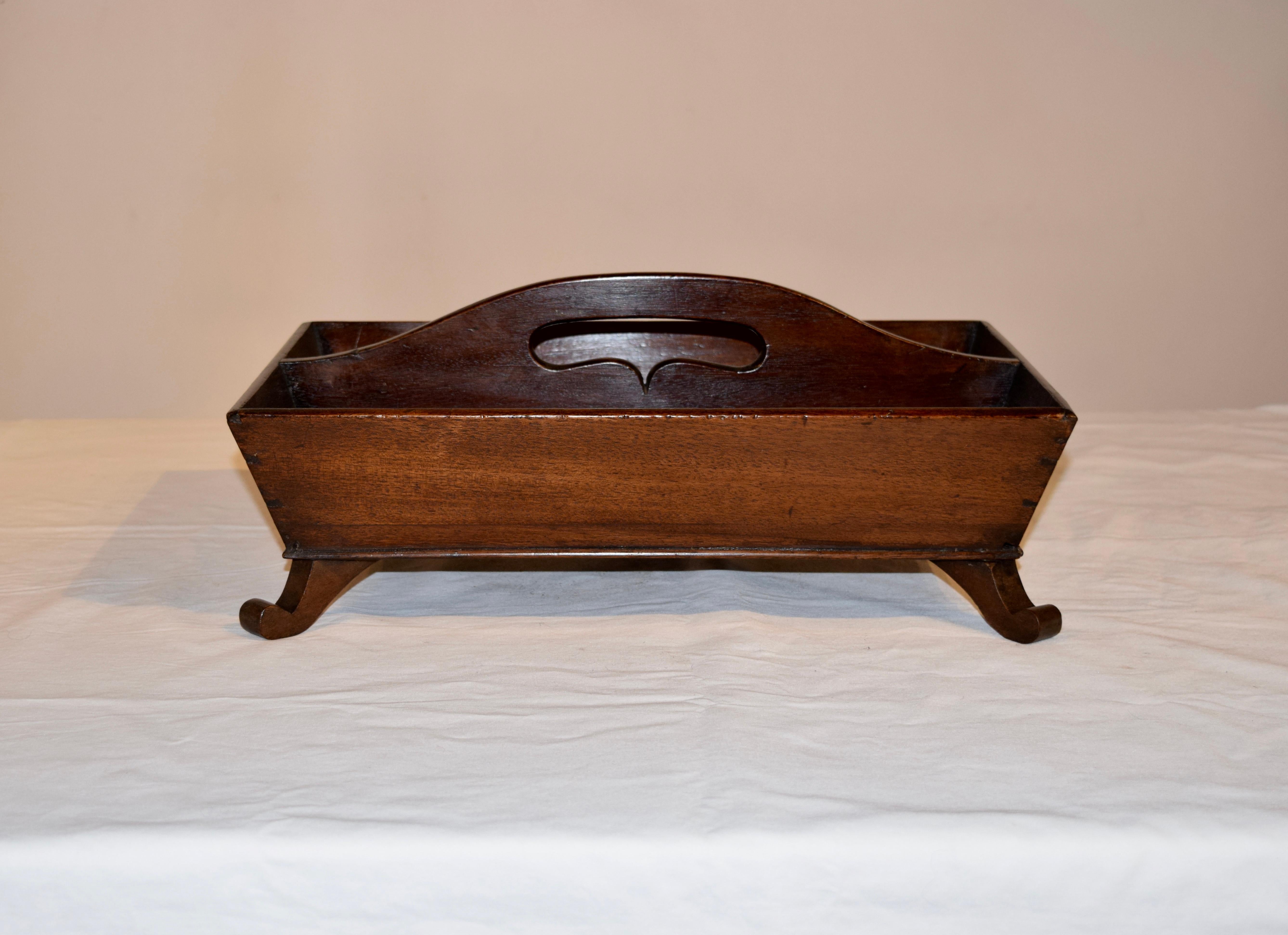 19th century English mahogany cutlery tray with a shaped handle on the top and splayed sides, supported on hand carved feet.
