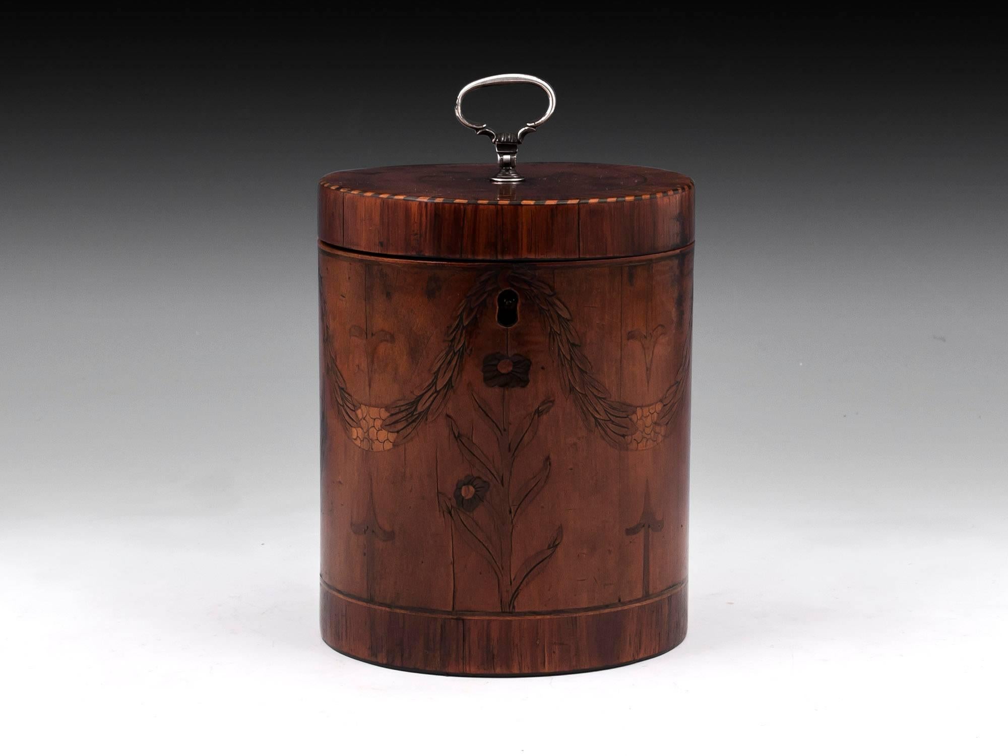 Rare cylindrical satinwood tea caddy, beautifully inlaid with engraved laurel swags and flowers with a chequered edging of boxwood and ebony. The top and bottom of the tea caddy have tulipwood crossbanding and boxwood and ebony stringing. Contains a