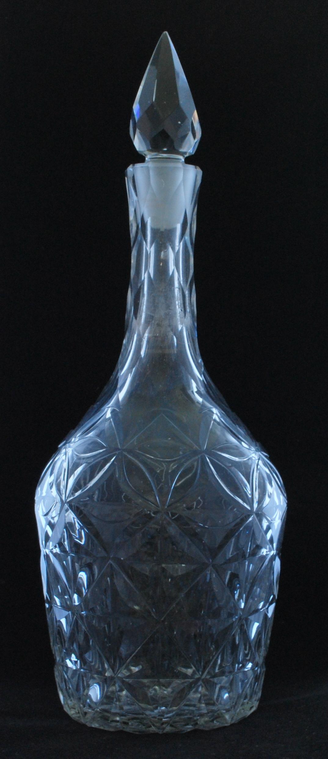 An Indian Club shaped decanter, decorated with wheel-cut interlocking circles and spire finial. Very much in the English style.