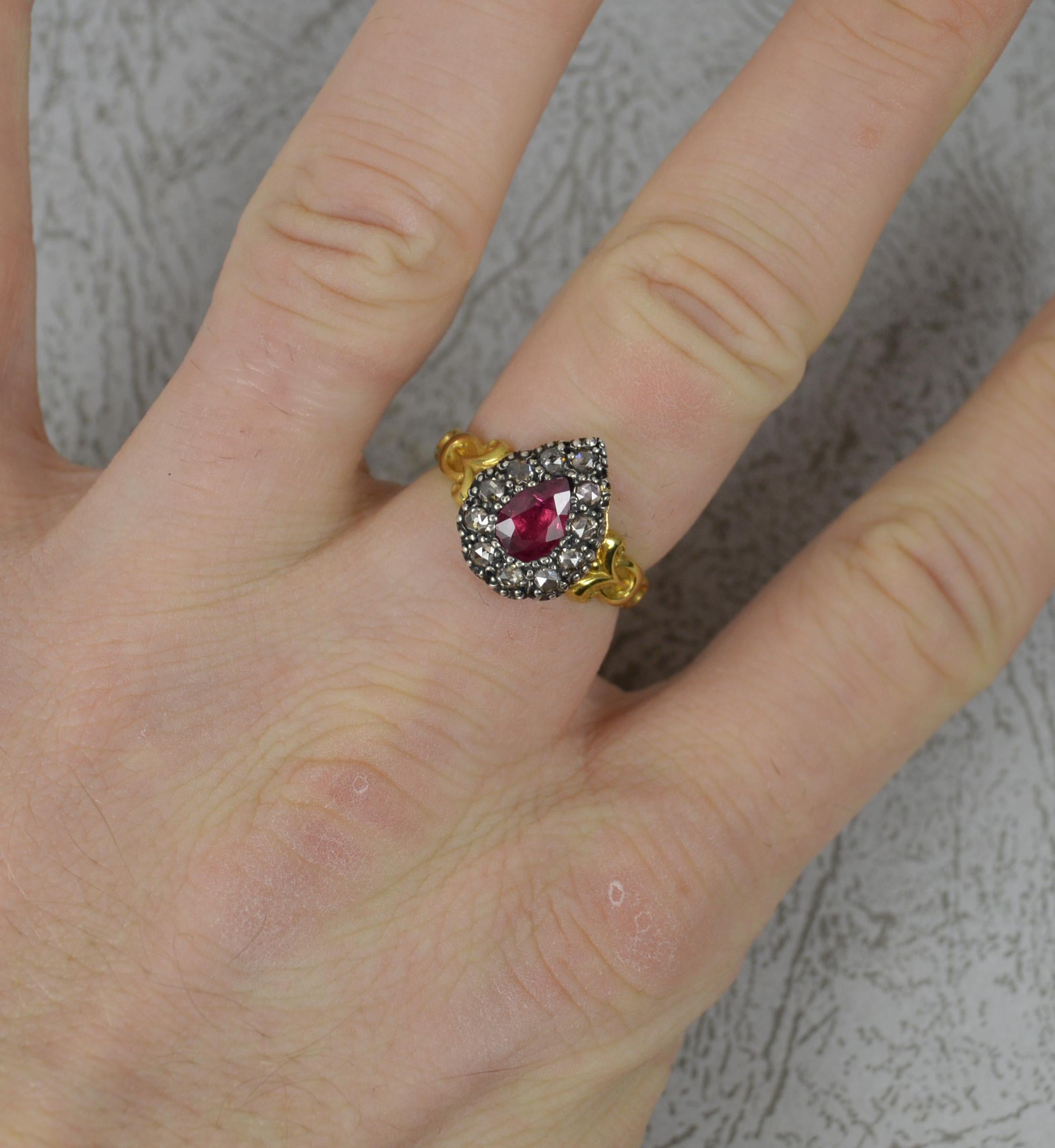 A Georgian design contemporary ring.
Solid 18 carat yellow gold shank and silver head setting.
Set with a pear shape 5mm x 7.25mm ruby in foiled back setting. Surrounding as 10 rose cut diamonds.
10.8mm x 13.7mm cluster head. Protruding 3mm off the