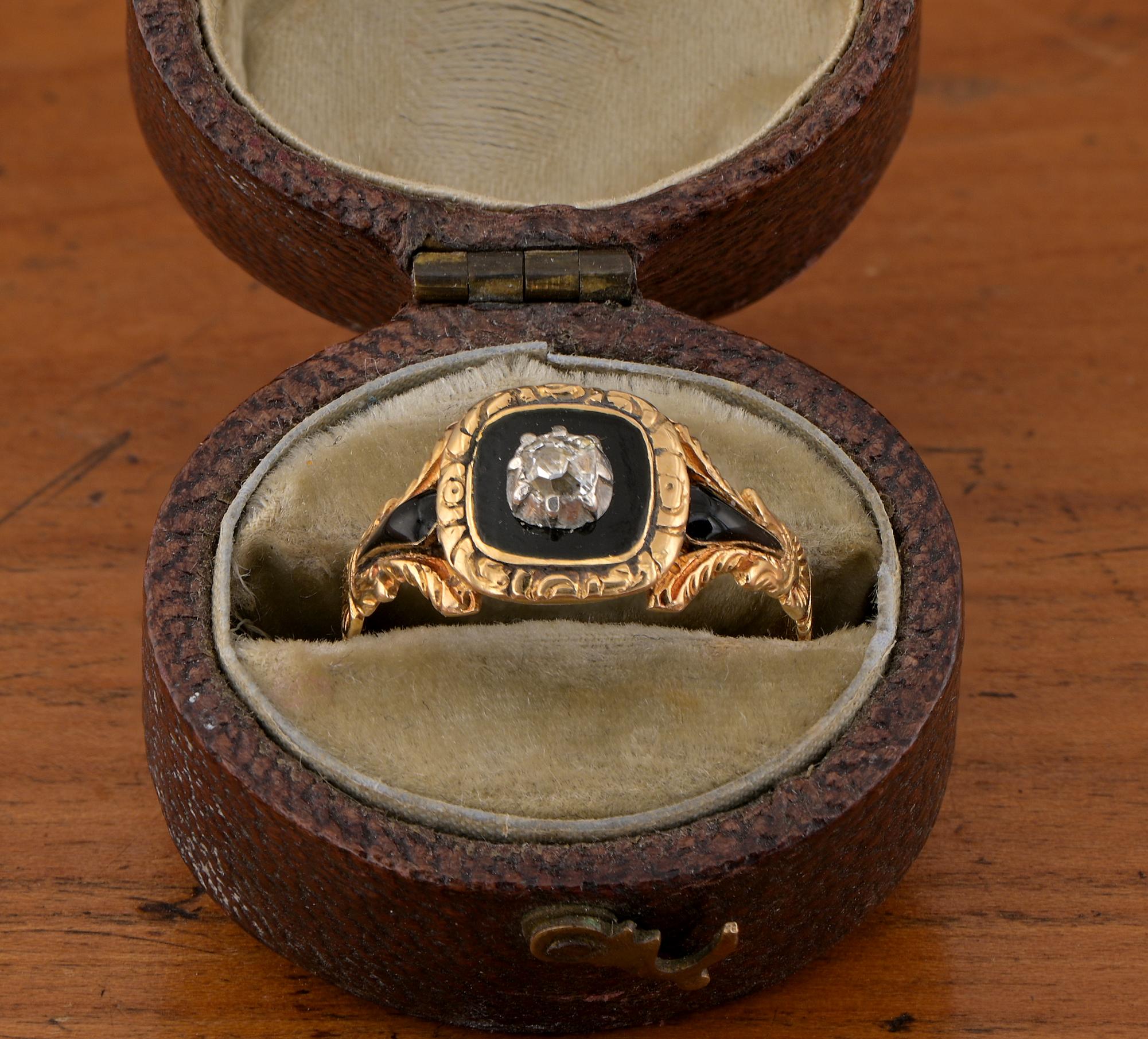 Bague de deuil en or jaune 18 carats, d'époque géorgienne, en diamant et émail noir, sertie d'un diamant de taille ancienne dans une bordure d'émail noir, les épaules gravées décorées d'autres émaux.
Avec un compartiment à médaillon recouvert de