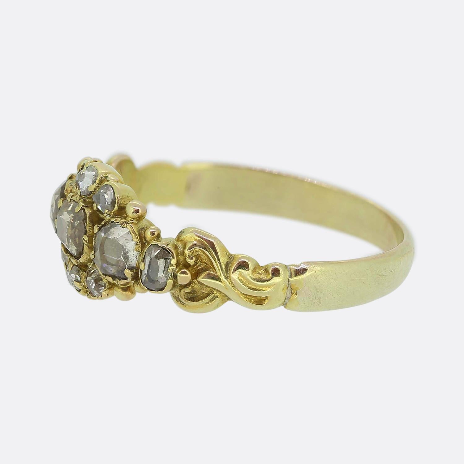 Here we have a charming diamond ring dating back to the Georgian period. The head of this dainty antique piece has been crafted from a rich 18ct yellow gold with ornately curvaceous shoulders flanking a delightful centralised cluster consisting of