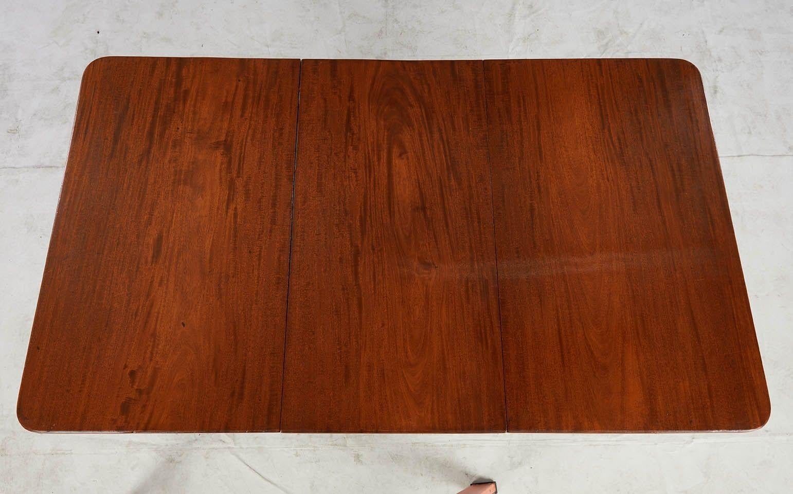 Bonne table de salle à manger à deux guéridons en acajou de George III, les plateaux en planches simples richement grainés avec des bords nervurés, reposant sur des bases tournées en anneau et en bobine au-dessus de pieds nervurés gracieusement