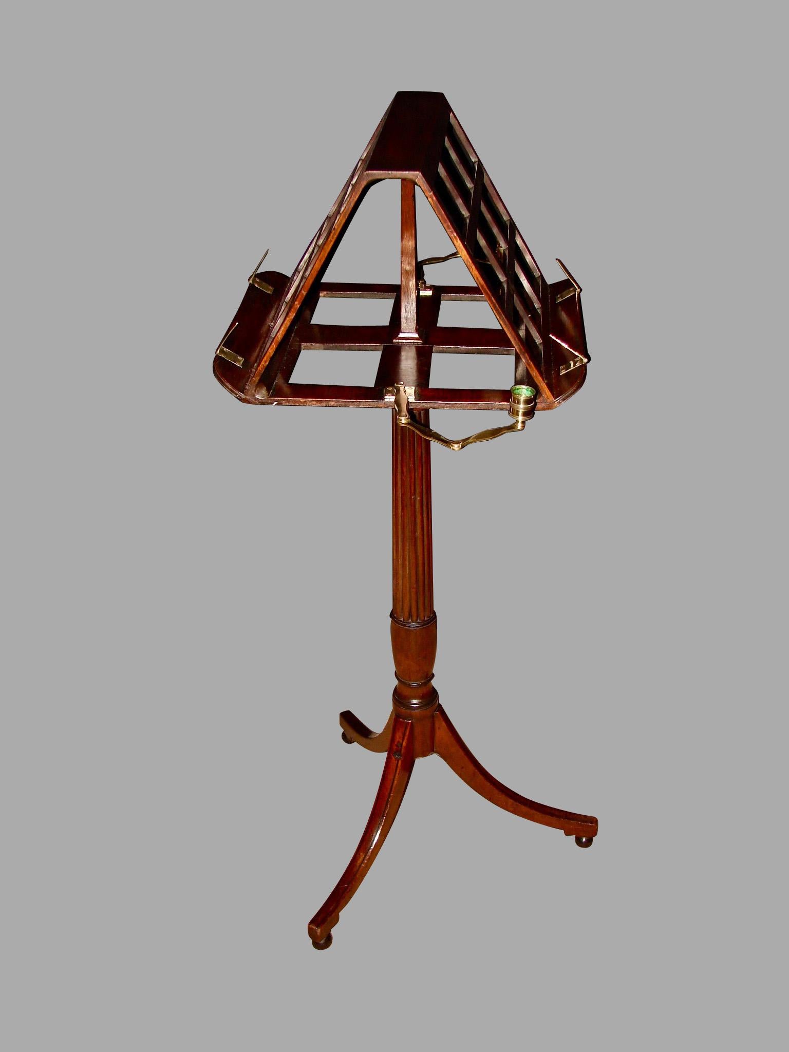 A George III mahogany adjustable duet music stand with brass candle arms, the 2 sided music holder resting on a reeded standard ending in a tripod base with replaced ball feet, circa 1790-1800.
