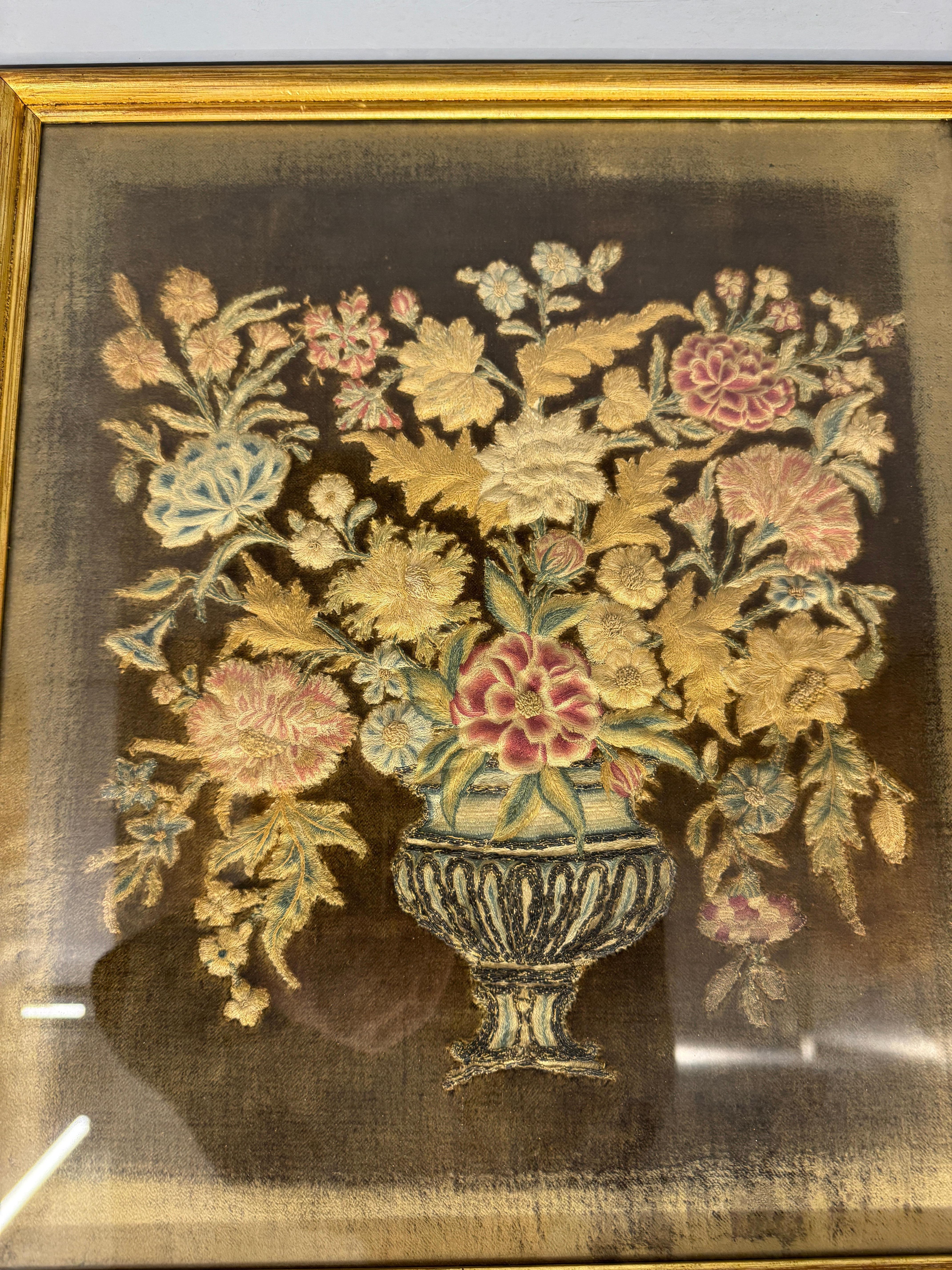Gesticktes georgianisches Paneel, um 1780. Sie ist fein aus farbiger Seide gearbeitet und zeigt eine Vase mit Blumen, die in der damaligen Zeit ein Symbol des Vertrauens waren. In einem modernen verglasten Rahmen.