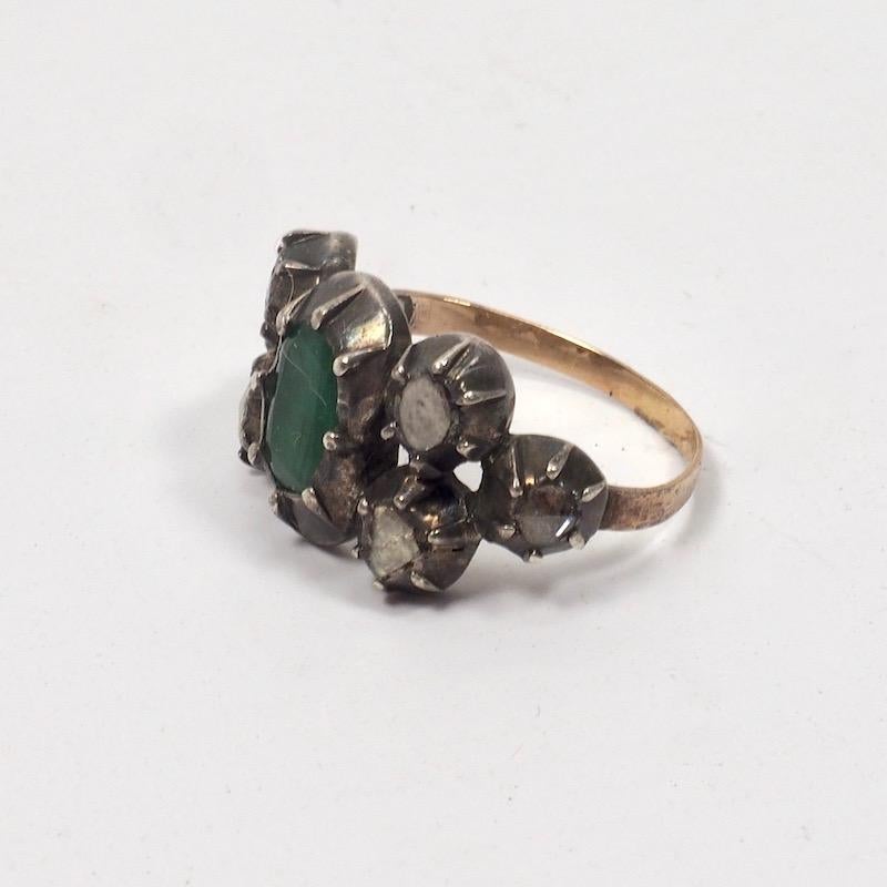 A rare Georgian foil backed table cut emerald ring with silver mounted rose cut diamonds on a golden band. Northern Europe, late 18th Century. Ring size 6 1/4.
