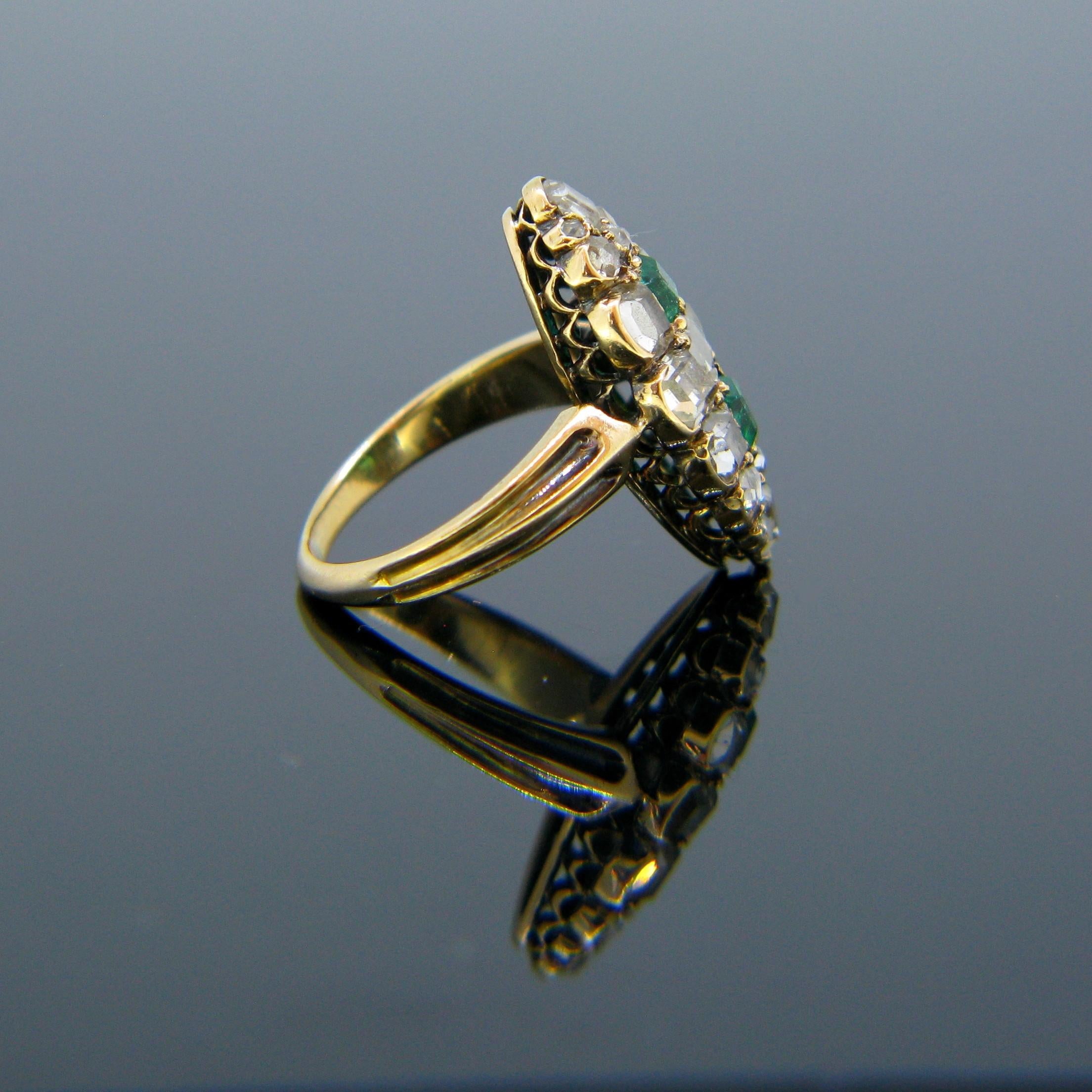 This antique ring is directly from the Georgian era. It is in the shape of a marquise and is set with two square emeralds and 18 table cut and rose cut diamonds foiled back. The ring is fully made in 18kt gold – not marked but tested. This ring is