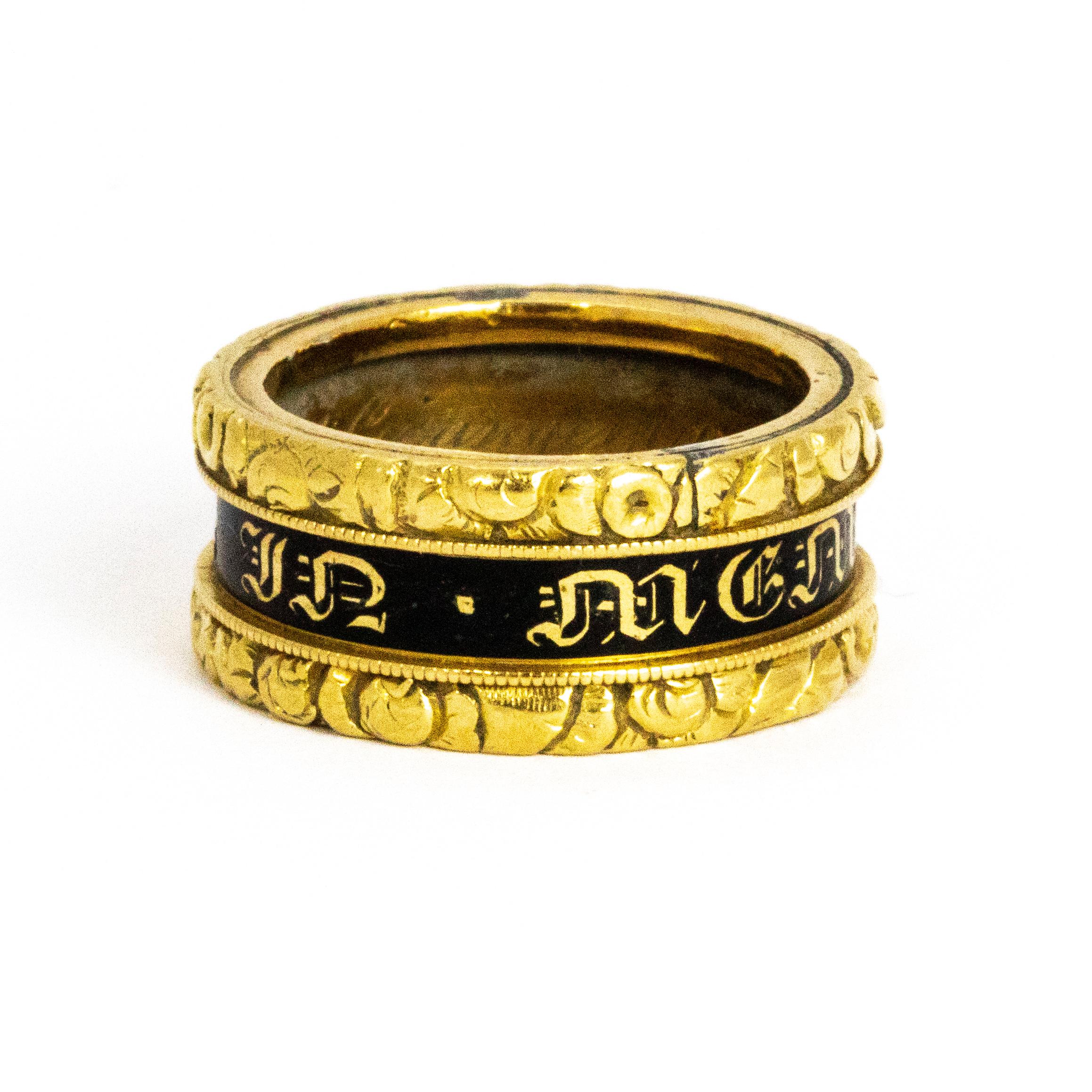 This stunning mourning ring has so much going on! On the outer of the ring there is a black enamel strip that flows around the whole band reading 'In Memory Of' and there are also two engraved gold bands that sandwich the black enamel. The