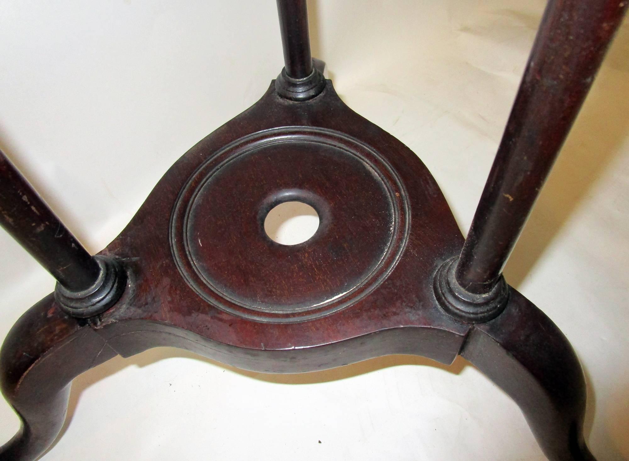 Georgian period English mahogany tripod pedestal featuring splayed legs with snake feet.
The width of the splayed legs is 19.50 inches the width of the top is 12.50 inches across circle.