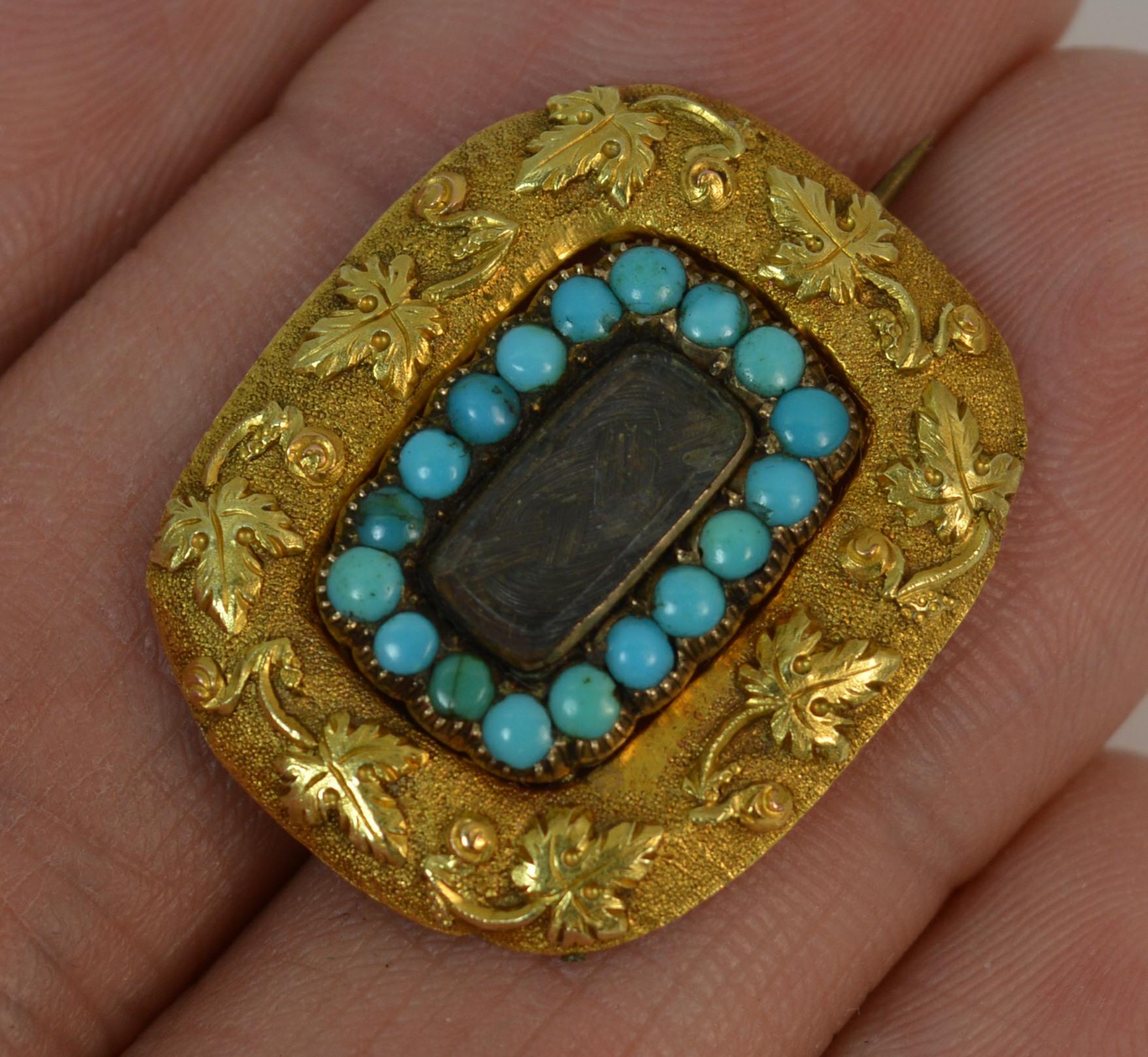 
A beautiful Georgian period brooch.

Solid 18 carat gold brooch example.

Designed with a locket panel of braided hair to the centre and full turquoise set border surrounding. The edge finished in 18ct gold with an ivy leaf pattern