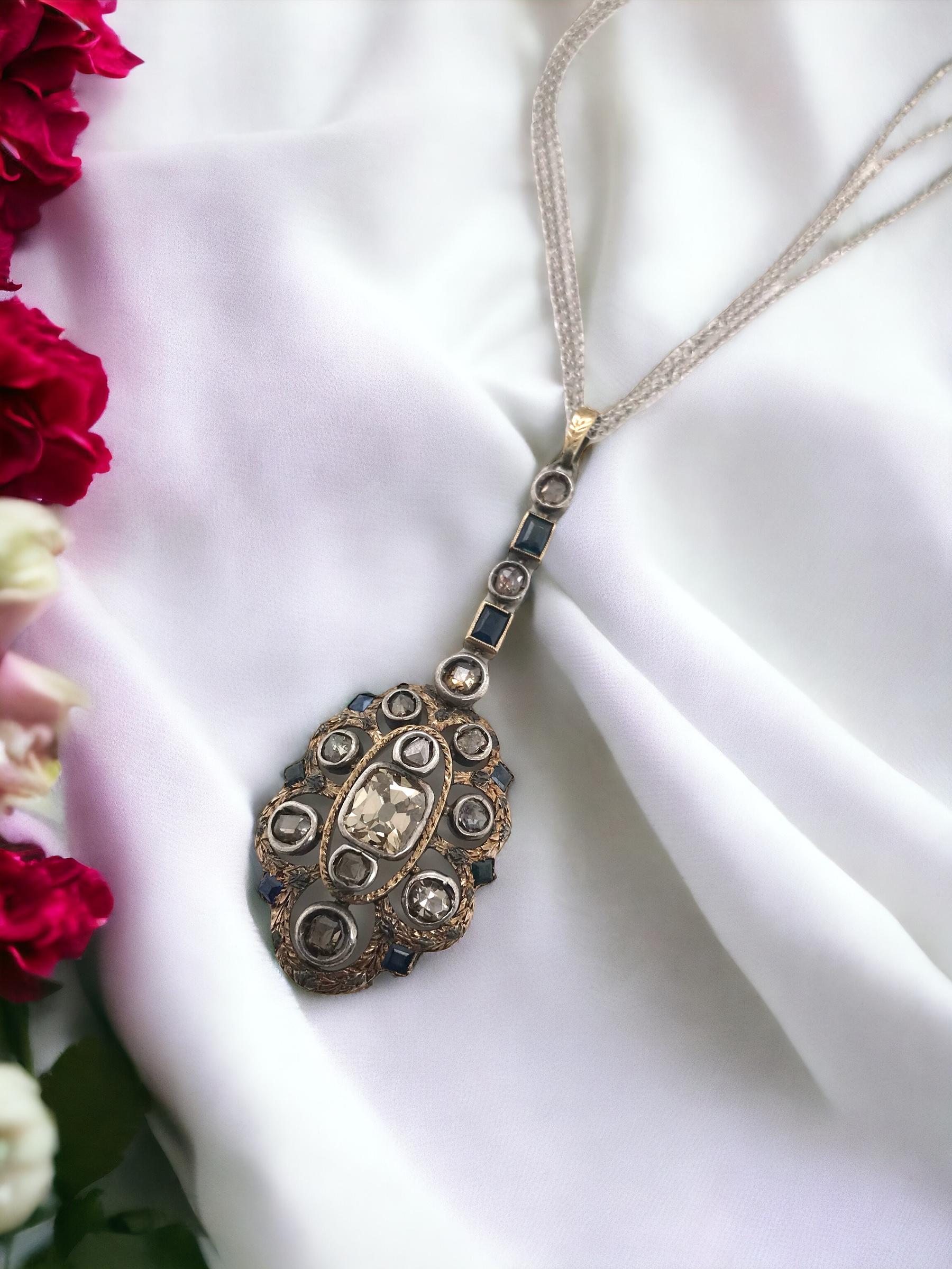 We are loving the earthy tones of this vintage beauty!
The beauty old mine cut diamond is accent with sapphires & rose cut diamonds, all set in gold that has been gilded with silver.

Necklace Details
Era: Georgian 1714 - 1840
Material: Gold &
