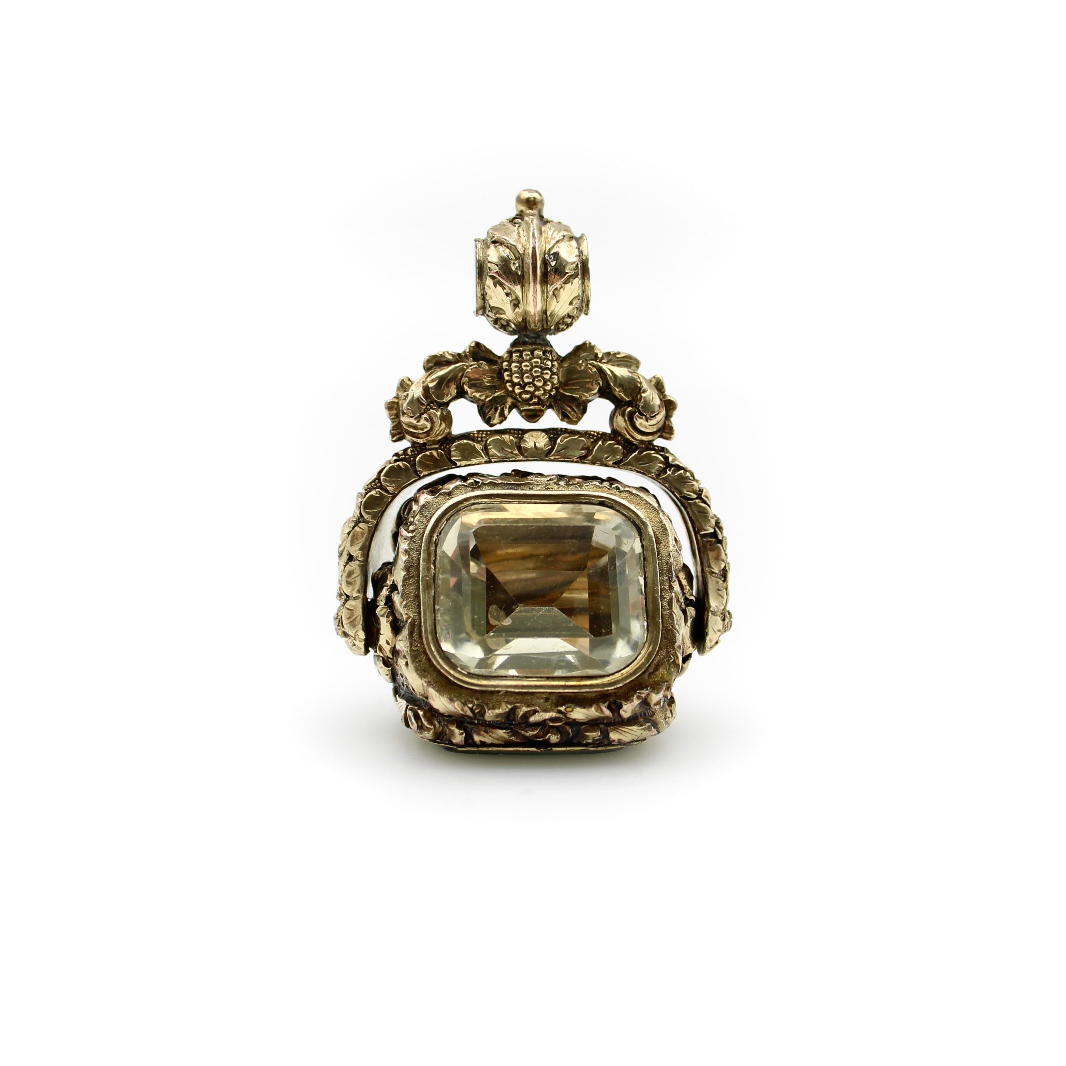 This impressive Georgian fob has three unique panels, and is built in a way that allows the fob to rotate, revealing the ornate details of each panel as the fob spins. One panel contains a sculptural still life behind a bezeled crystal pane, like a