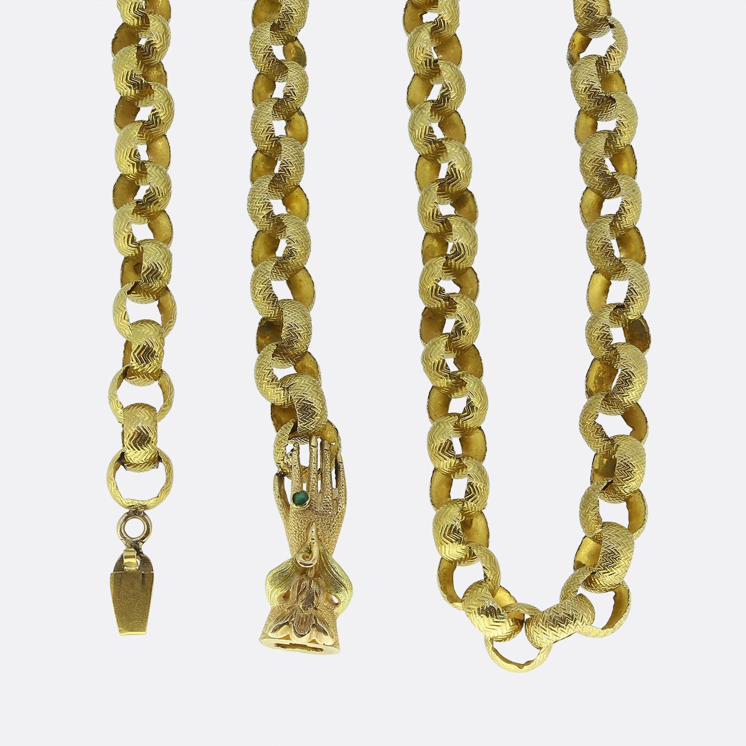Here we have a lovely oversized antique muff chain with a raised ornate zig-zag design travelling consistently throughout each individual belcher style link. The piece is finished with a beautifully crafted textured model hand acting as the clasp