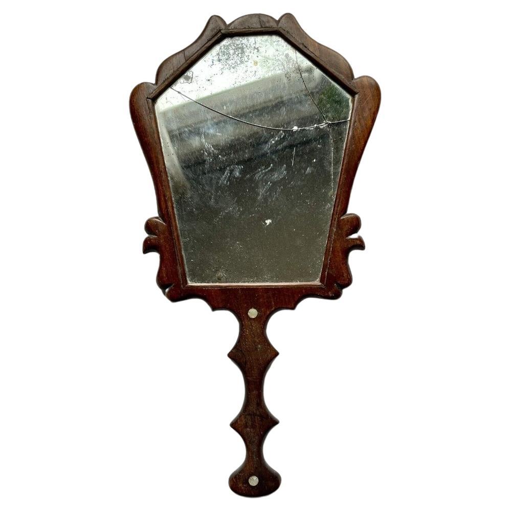Questo antico specchio a mano è un pezzo straordinario che un tempo aggiungeva eleganza al tavolo da toeletta di un'elegante signora georgiana. Realizzato in Inghilterra intorno al 1820, durante il tardo periodo georgiano. Presenta due splendidi