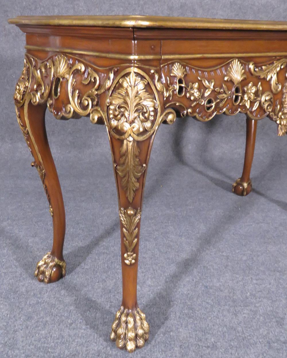 This is a whimsical console or sofa table with gilded details and faces on both sides.