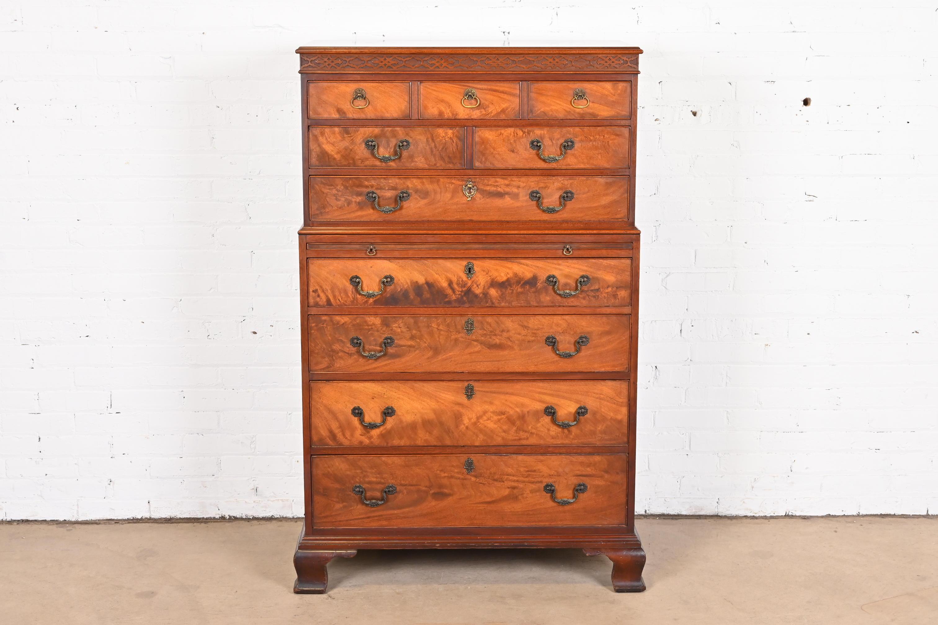 A gorgeous Georgian or Chippendale style seven-drawer chest on chest highboy dresser

In the manner of Baker Furniture

USA, circa 1940s

Carved mahogany, with stunning flame mahogany drawer fronts, leather top pull-out surface, and original