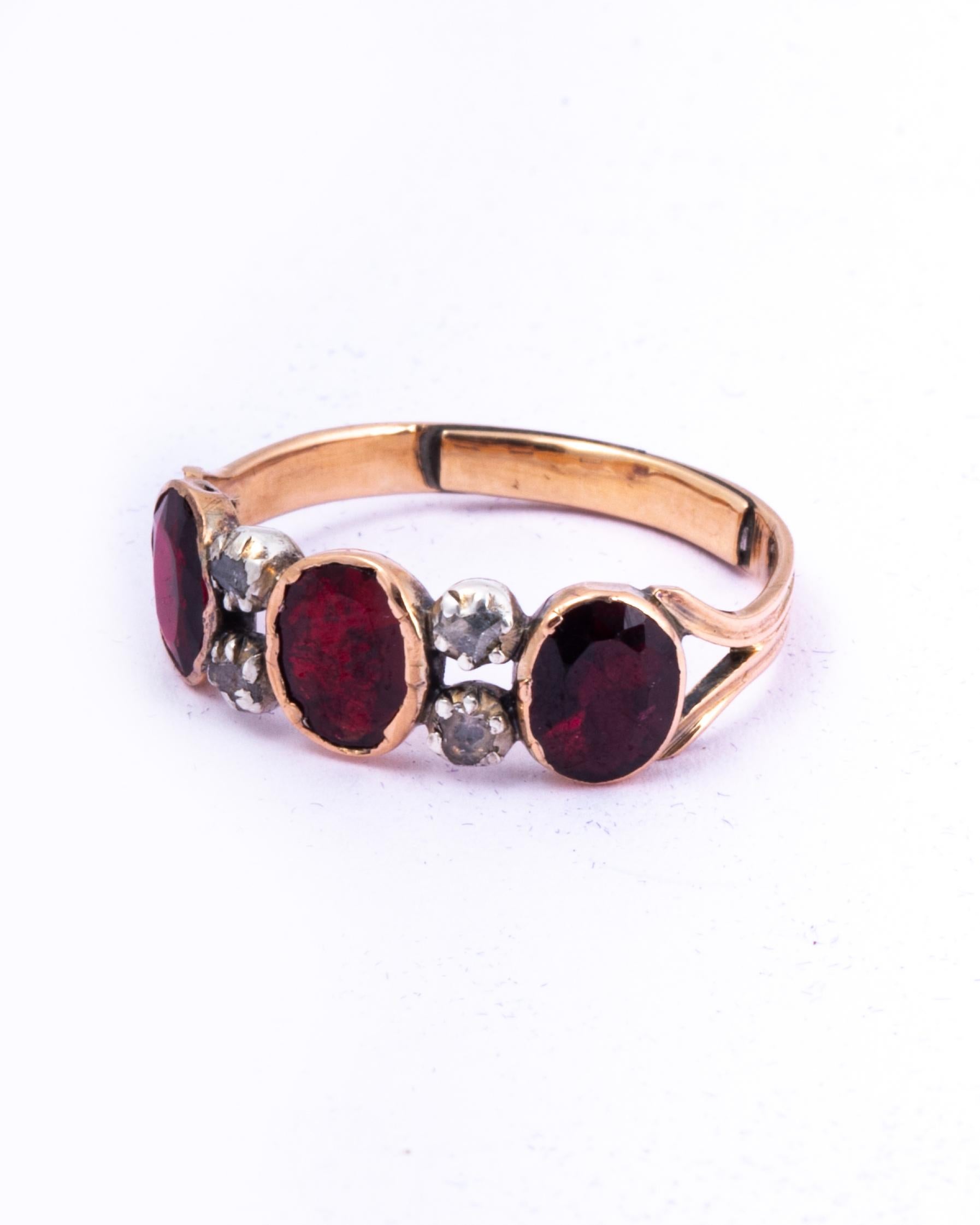 The gorgeous georgian flat cut garnets in this band are a wonderful large size. When wearing the band it has a lovely chunky look to it with the added sparkle of the pairs of rose cut diamonds between the red stones.

Ring Size: J or 4 3/4
Band