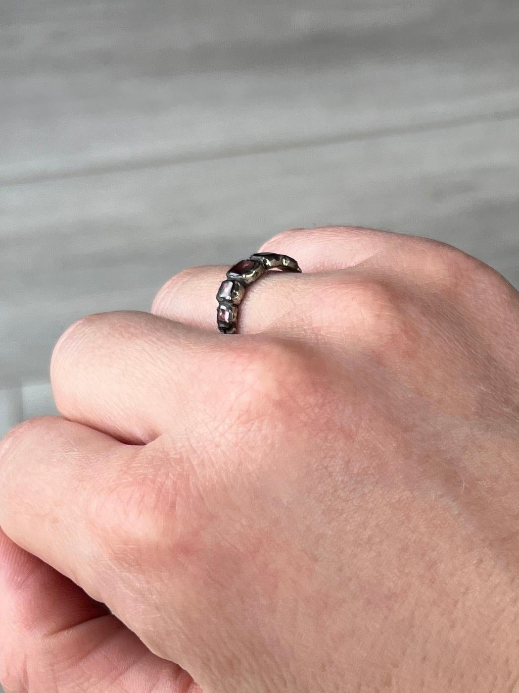 The gorgeous georgian flat cut garnets in this band are wonderful. This ring is modelled in silver and holds a total of five flat cut garnets with foiled back. 

Ring Size: L 1/2 or 6 
Band Width: 5mm

Weight: 1.1g