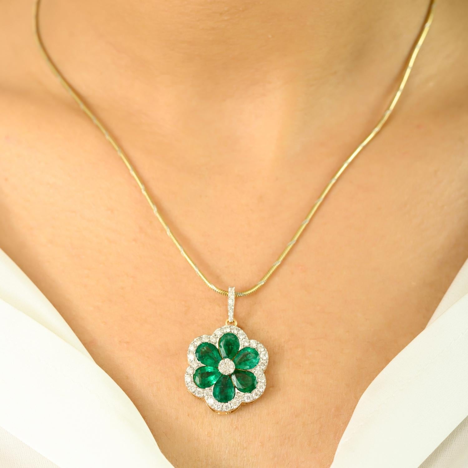 Irradiant d'une élégance intemporelle et d'une beauté naturelle, ce pendentif exquis est réalisé en riche or jaune 18 carats et dessiné dans un délicat motif floral. Whiting, 3,3 carats d'émeraudes luxuriantes en forme de poire disposées en pétales