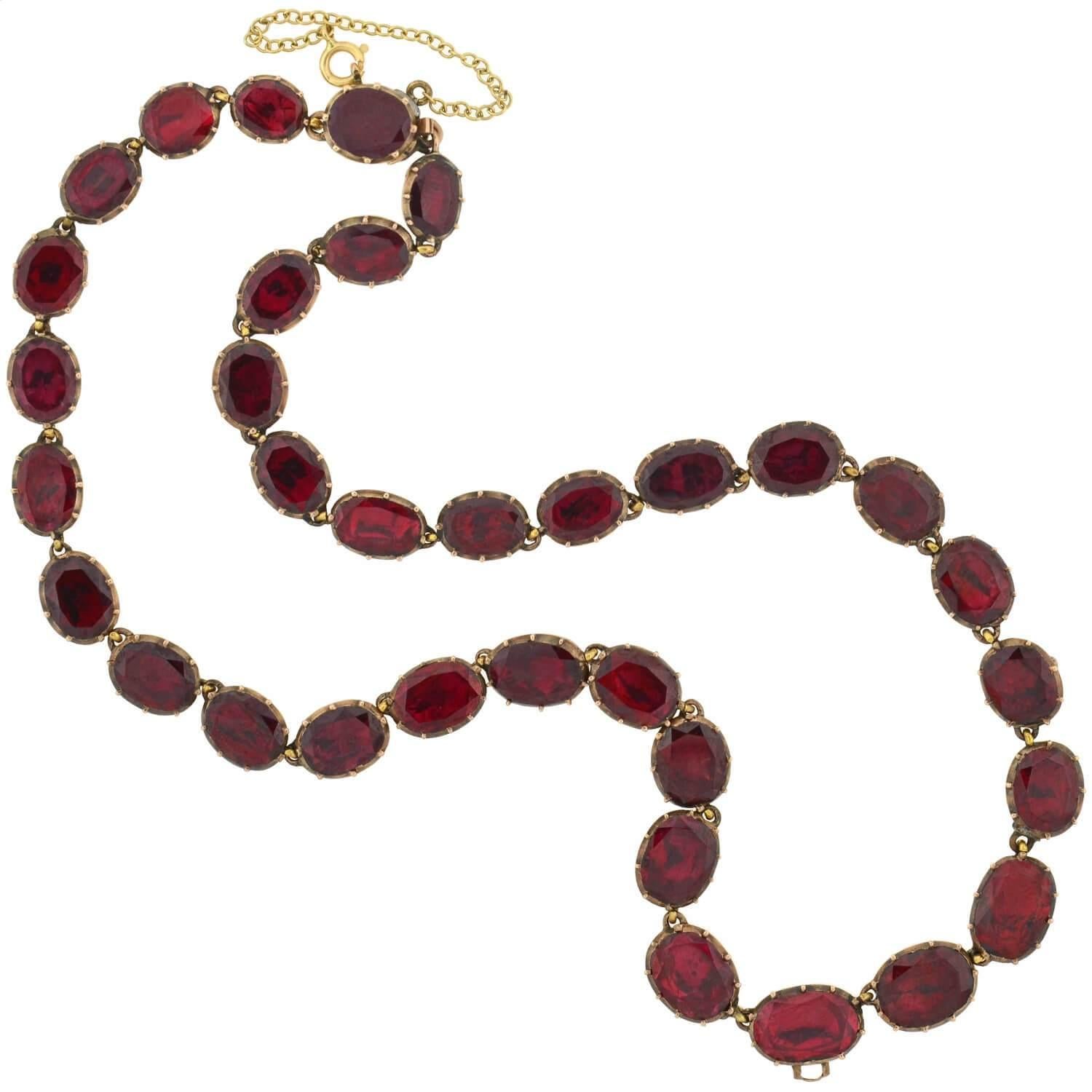 An absolutely stunning garnet necklace from the Georgian (ca1750) era! Crafted in 14kt rose gold, this beautiful piece is comprised of 34 garnet links that connect together to form a gorgeous collar necklace. The oval-shaped stones graduate slightly
