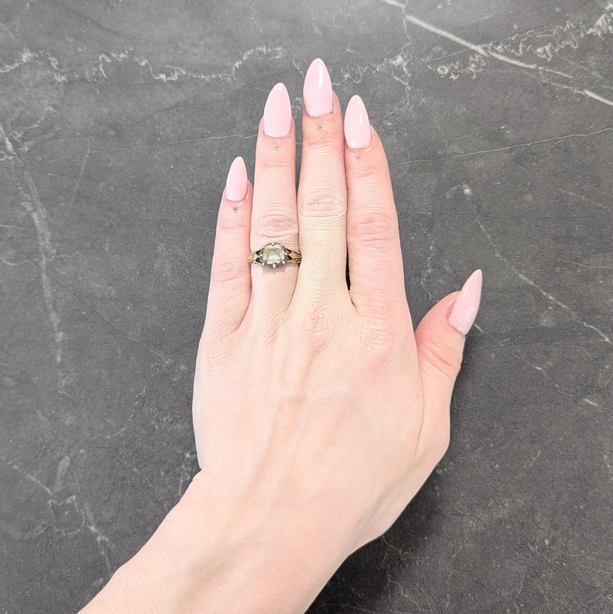 Centering an antique rectangular step cut diamond diamond weighing approximately 1.25 carats
Light brown color and quality consistent with age - set in a colette style bezel
Silver-topped and backed by foil - displaying a luminous reflective