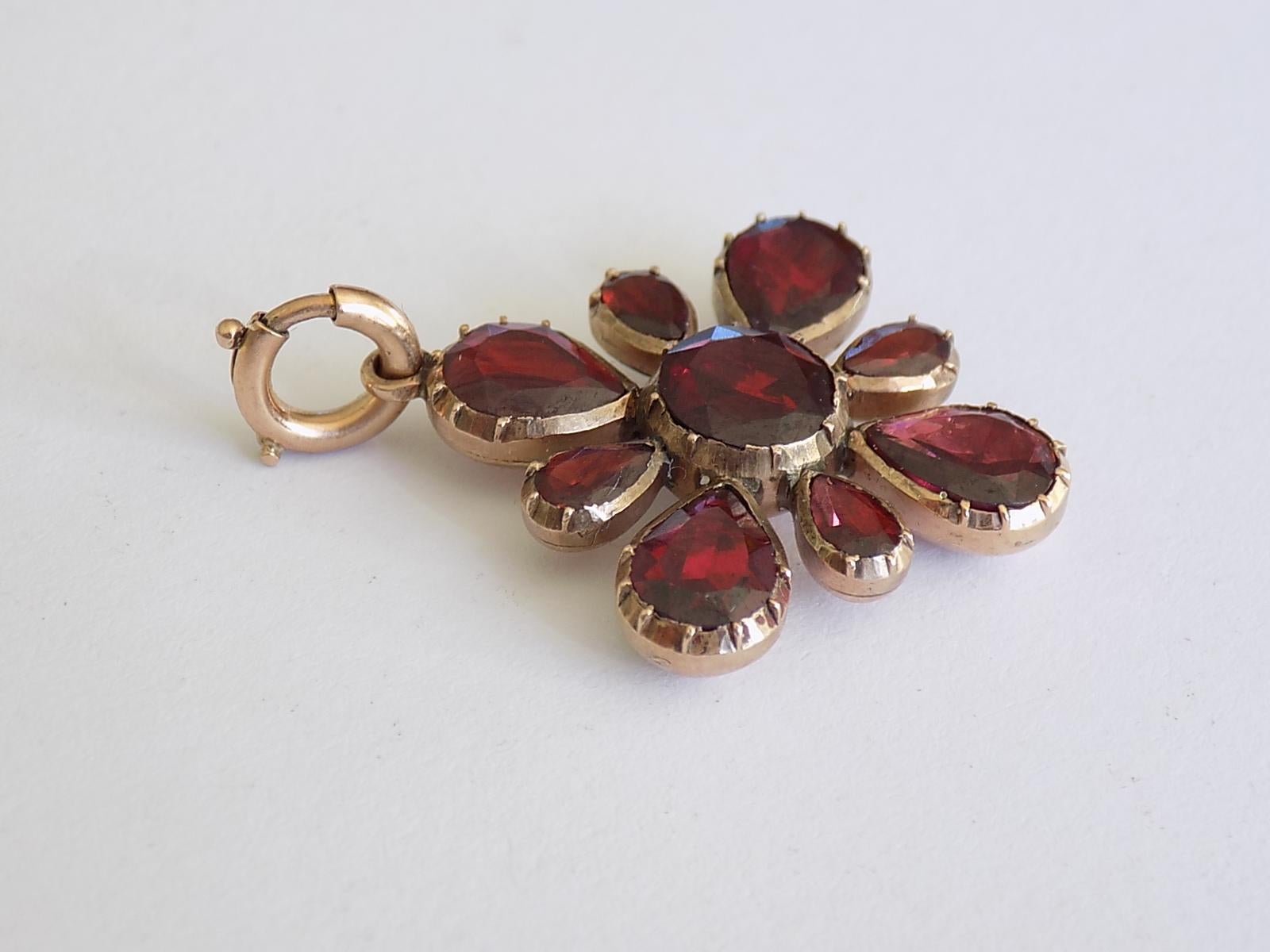 A Georgian c.1800 9 Carat Gold and Garnet pendant. The Garnet in foil closed back setting. English origin.
Drop 34mm, width 25mm.
Weight 4.8gr.
Unmarked, tested 9 carat gold.