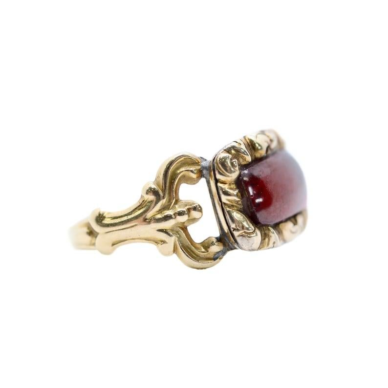 Aston Estate Jewelry Presents:

An original Georgian period cabochon cut foil backed garnet mourning ring. Centered by a rectangular cabochon cut vivid red garnet, and framed by hand engraved detailing. The original shank mates beautifully to the