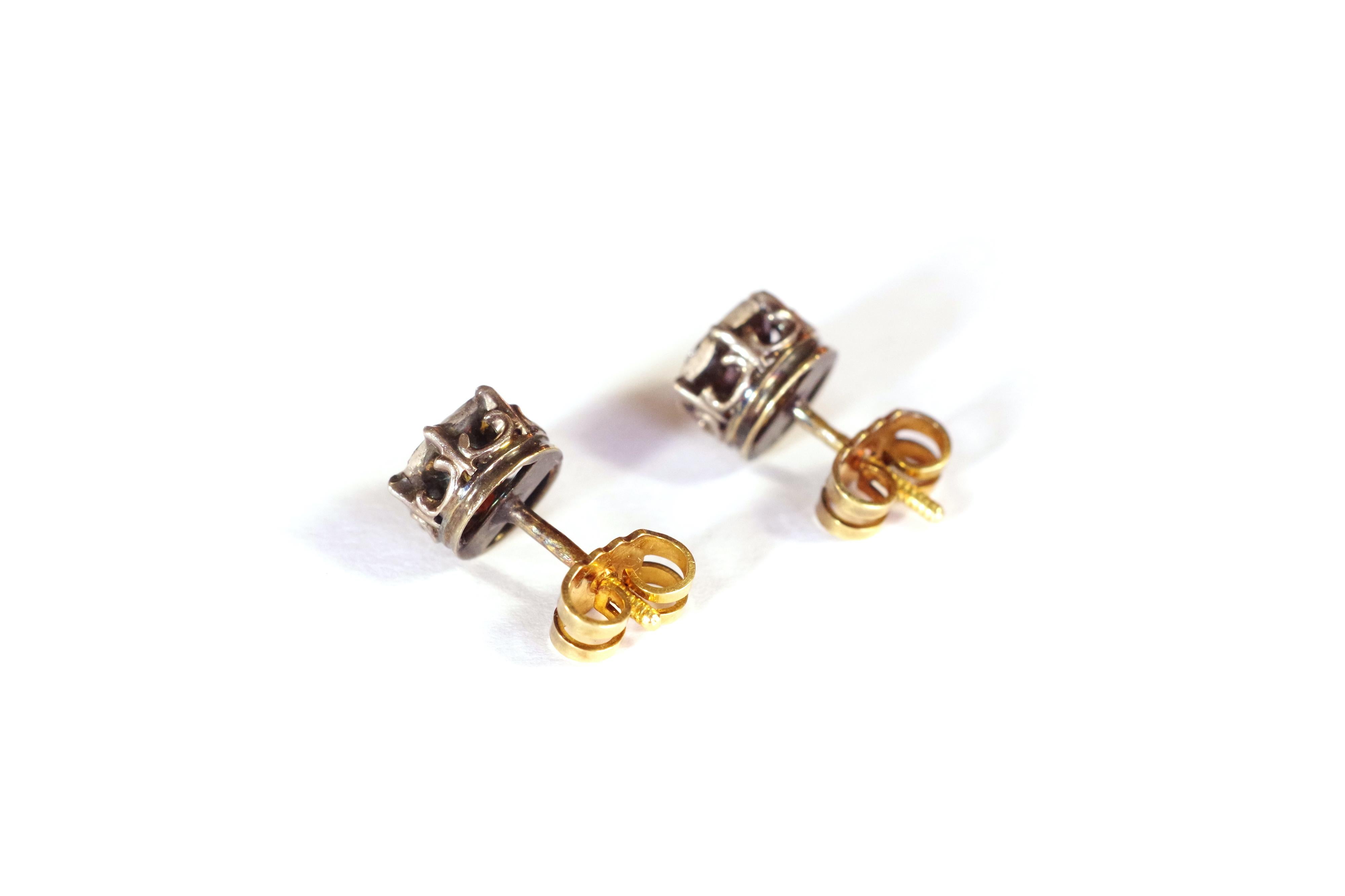 Georgian foiled diamond stud earrings in yellow 18 karat gold and silver. Pair of stud earrings set with a rose cut foiled diamond. The paillon is a yellow coloured metal sheet giving a special luminous effect to the diamond. The diamond is set with