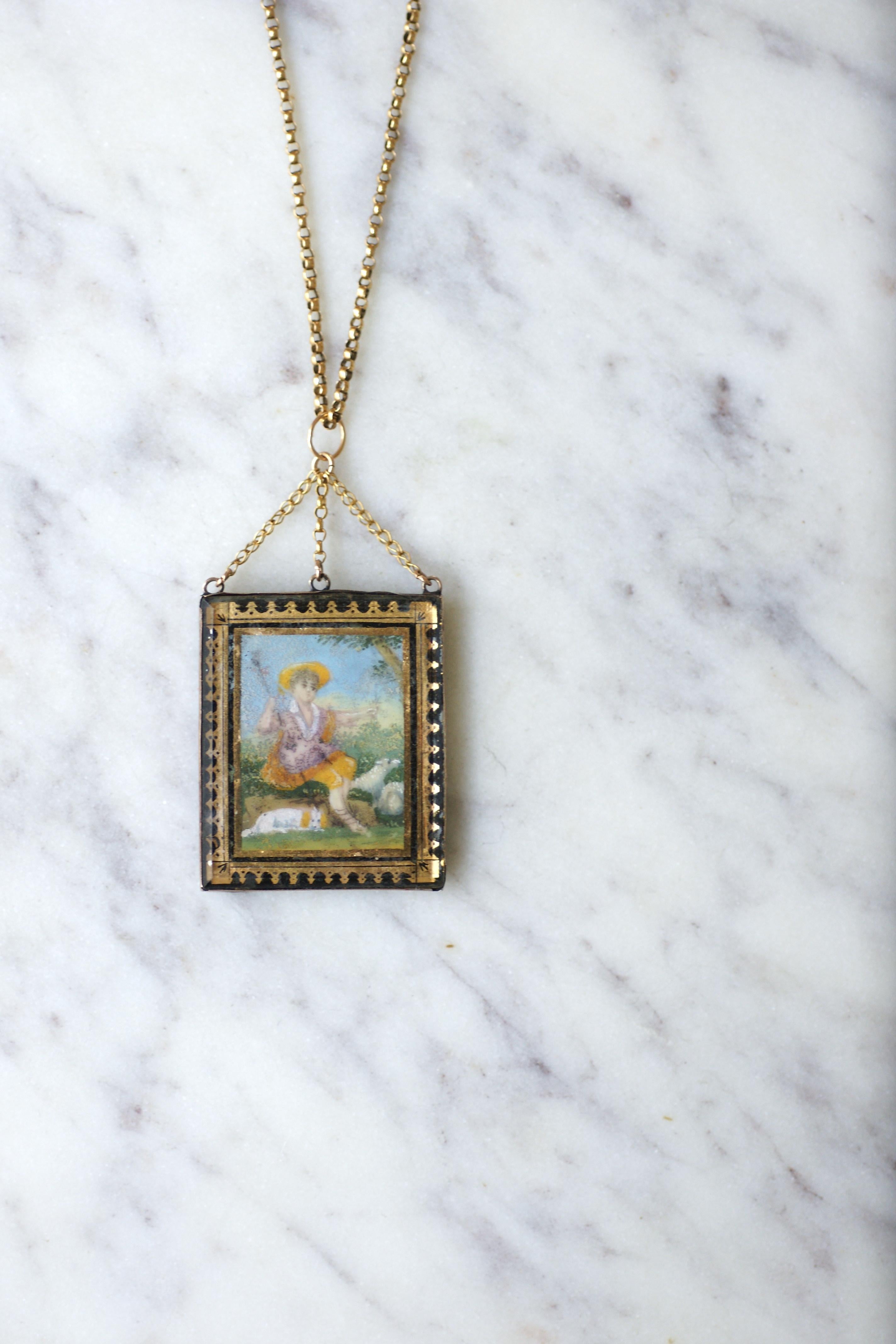 18kt yellow gold chain adorned with a locket clasp and holding a 18kt rose gold (hallmark: rooster) ‘verre eglomisé’ locket.

The face is showing a 18th Century style shepherd miniature. Back is foiled with a square fabric.

'Verre églomisé' is a