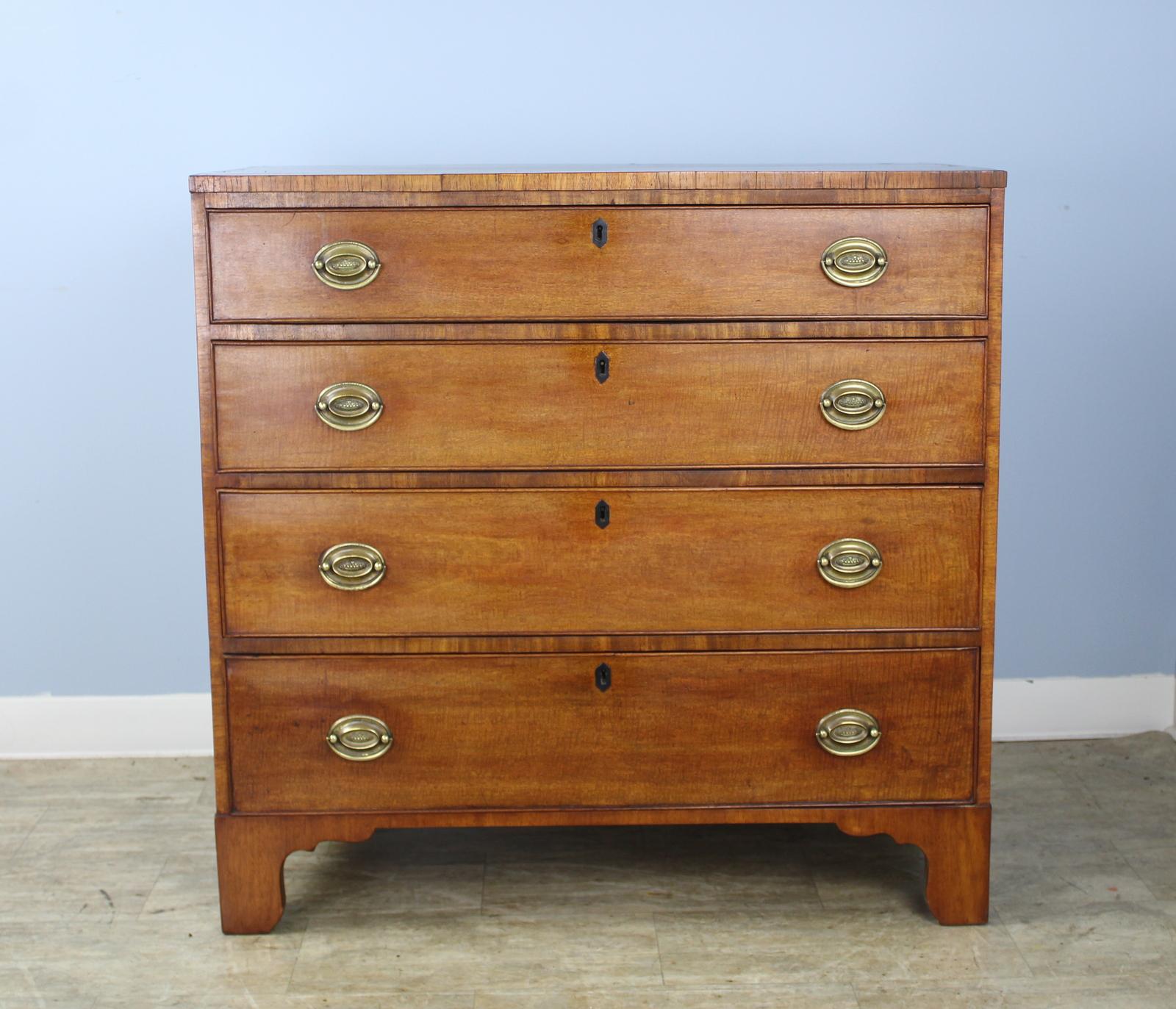 An early and beautifully grained fruitwood chest of drawers with original ogee feet and original inlaid ebony stringing on top. Drawers slide and shut snugly and easily, and are clean inside. Good golden honey colored fruitwood.